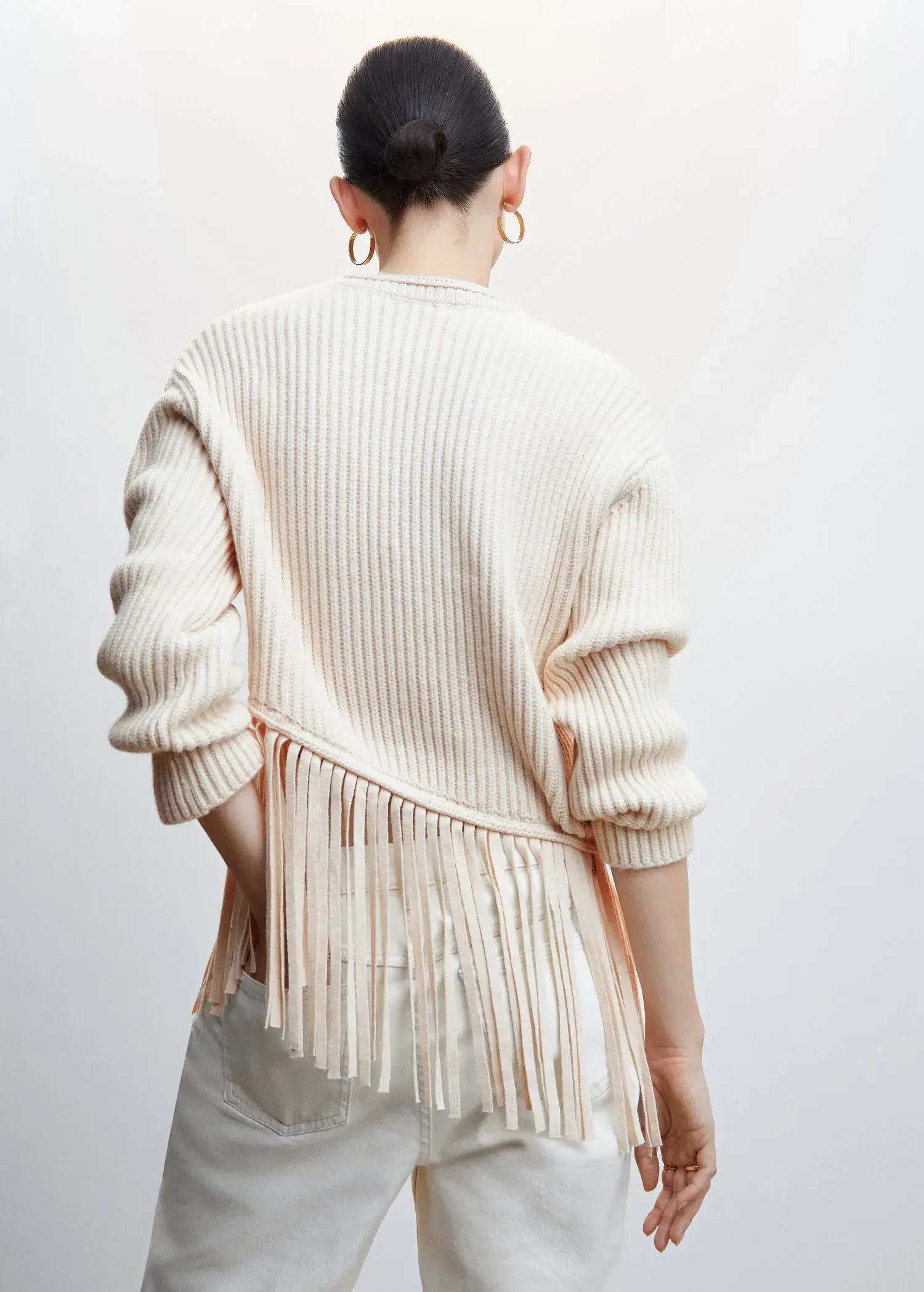 Mango Fringed hem sweater. a woman wearing a white sweater with fringes. 