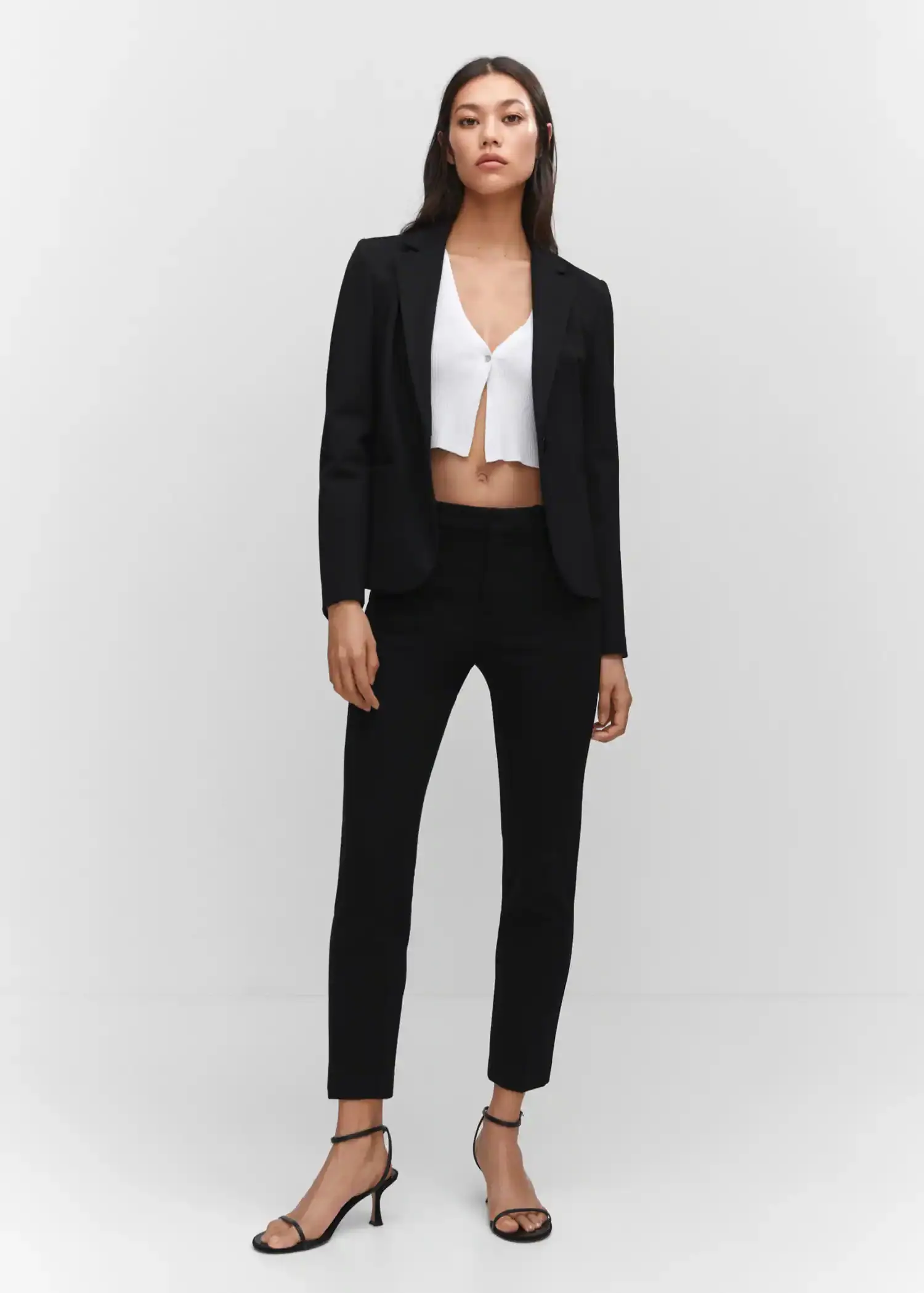 Mango Rome-knit straight trousers. a woman wearing a black suit and a white top. 