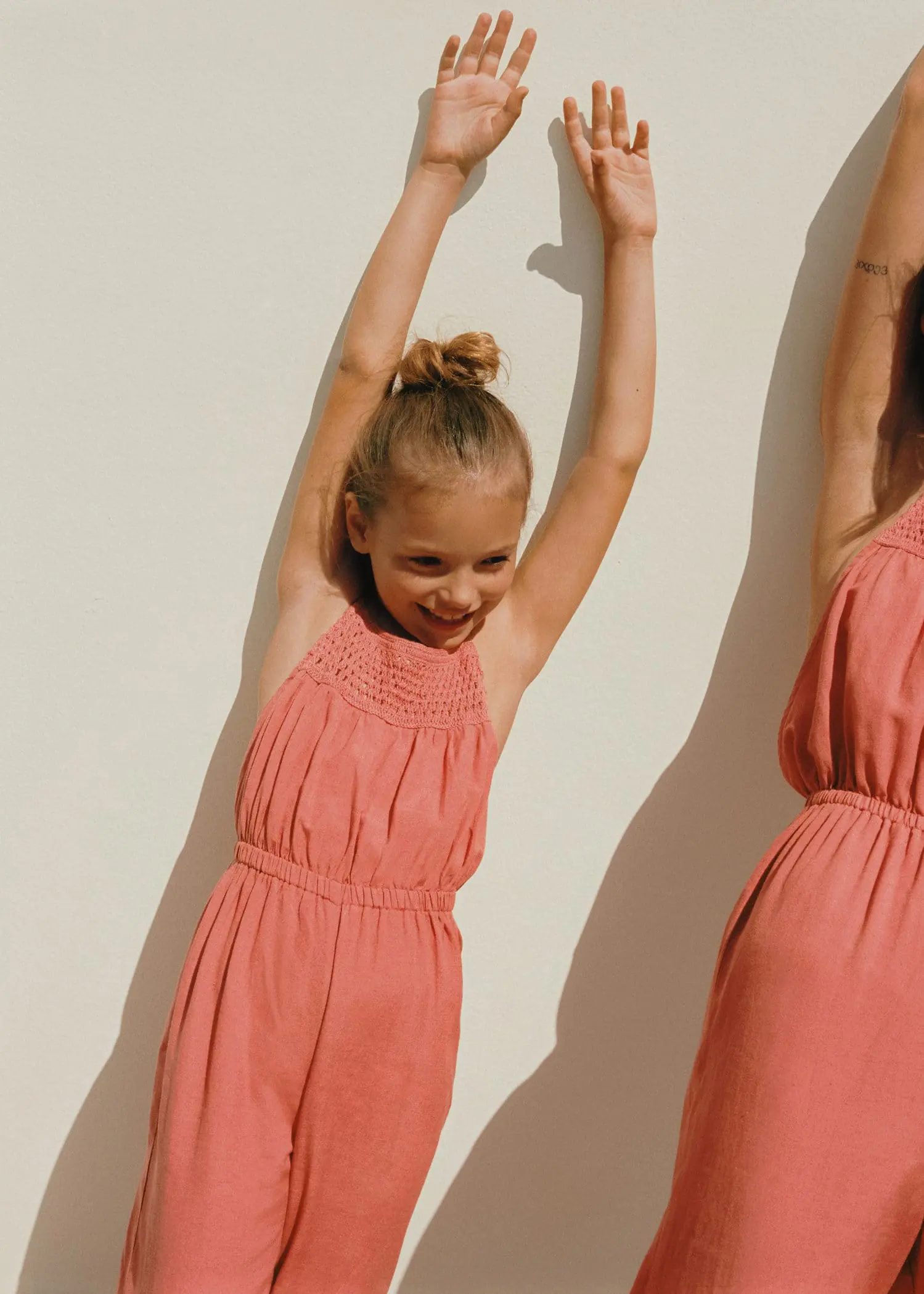 Mango Ruched long jumpsuit. a young girl in a pink dress standing in front of a mirror. 