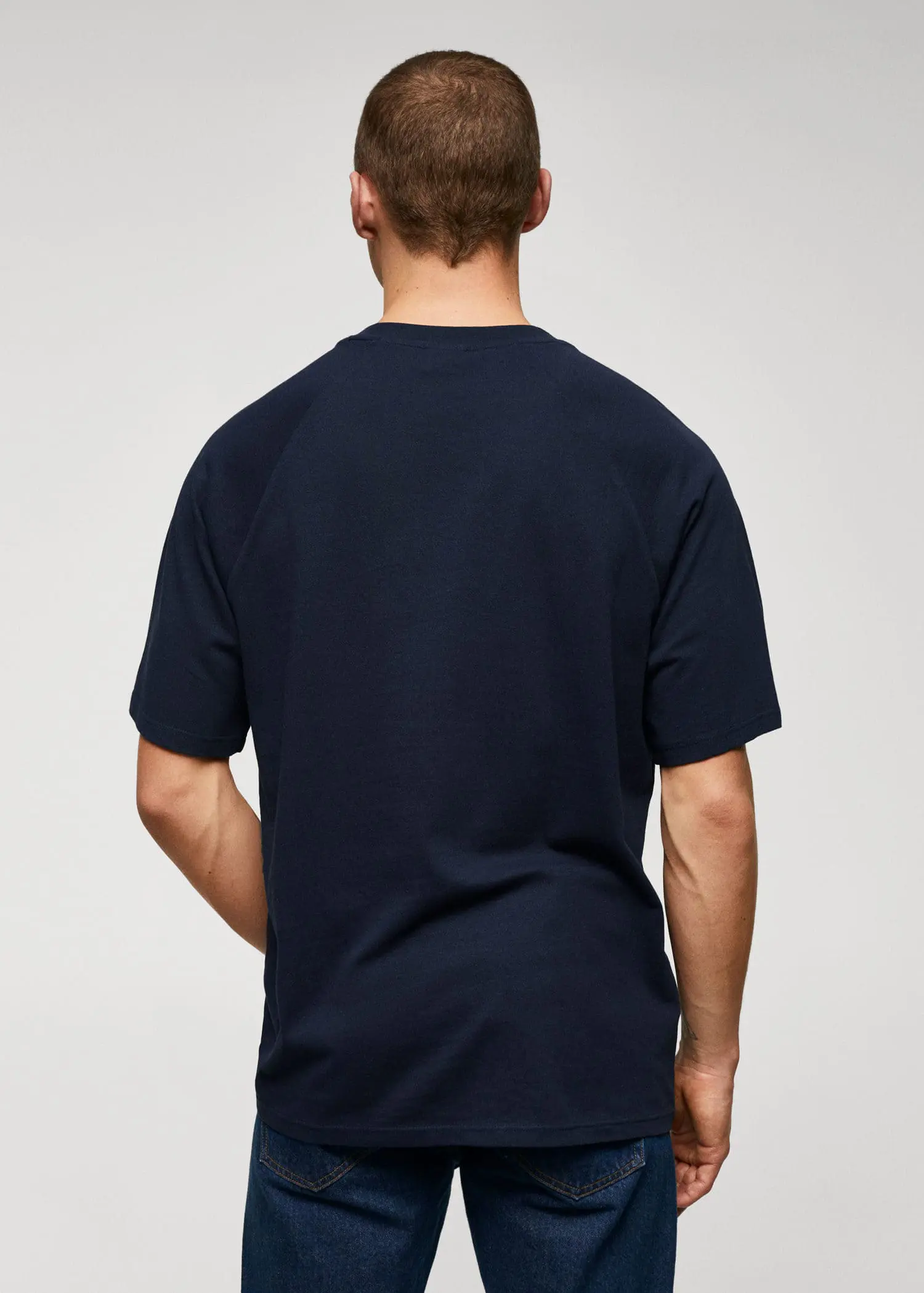 Mango Textured cotton-linen t-shirt. a man in a black shirt is standing up 