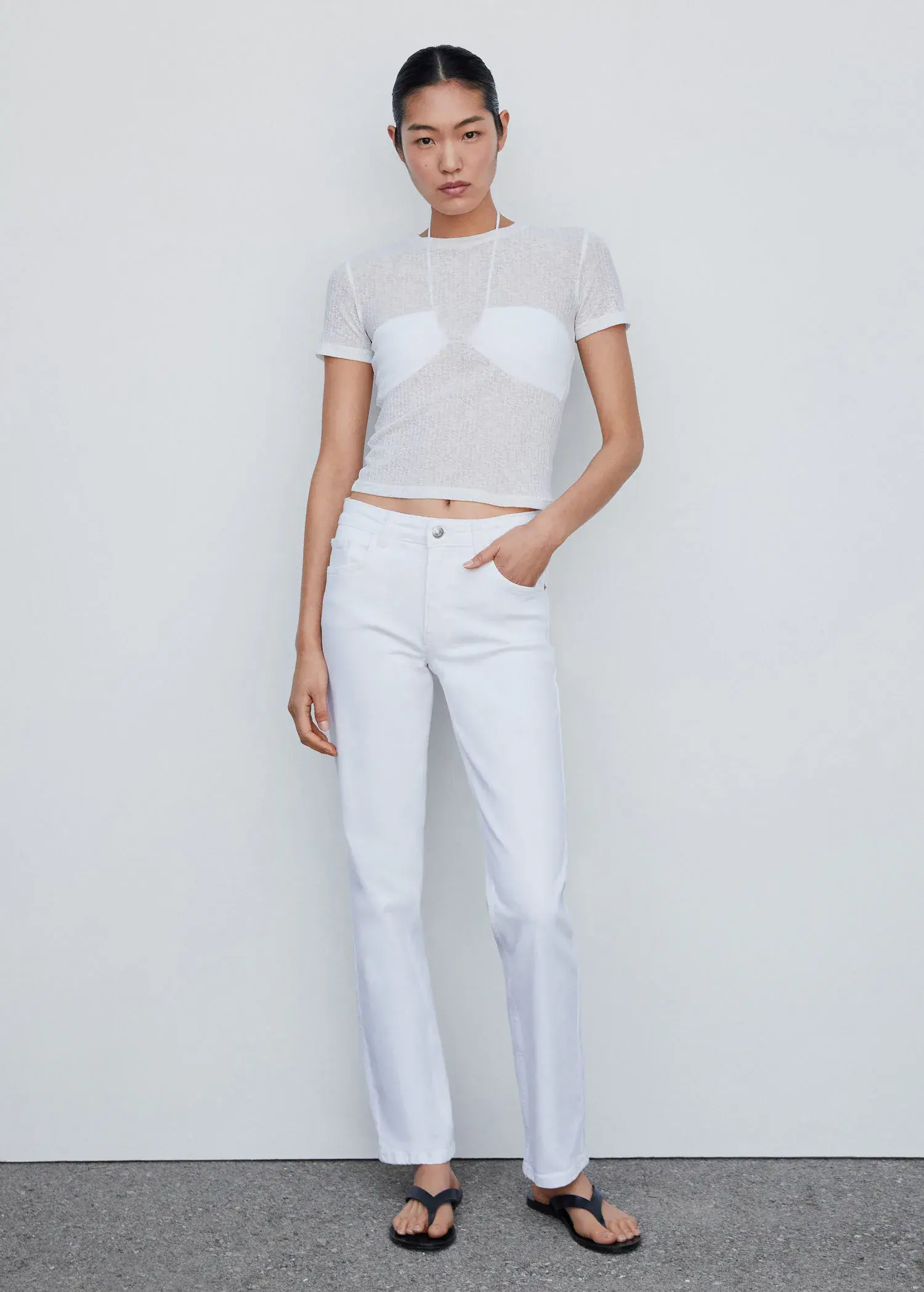 Mango Medium-comfort straight jeans. a woman wearing all white poses for a picture. 
