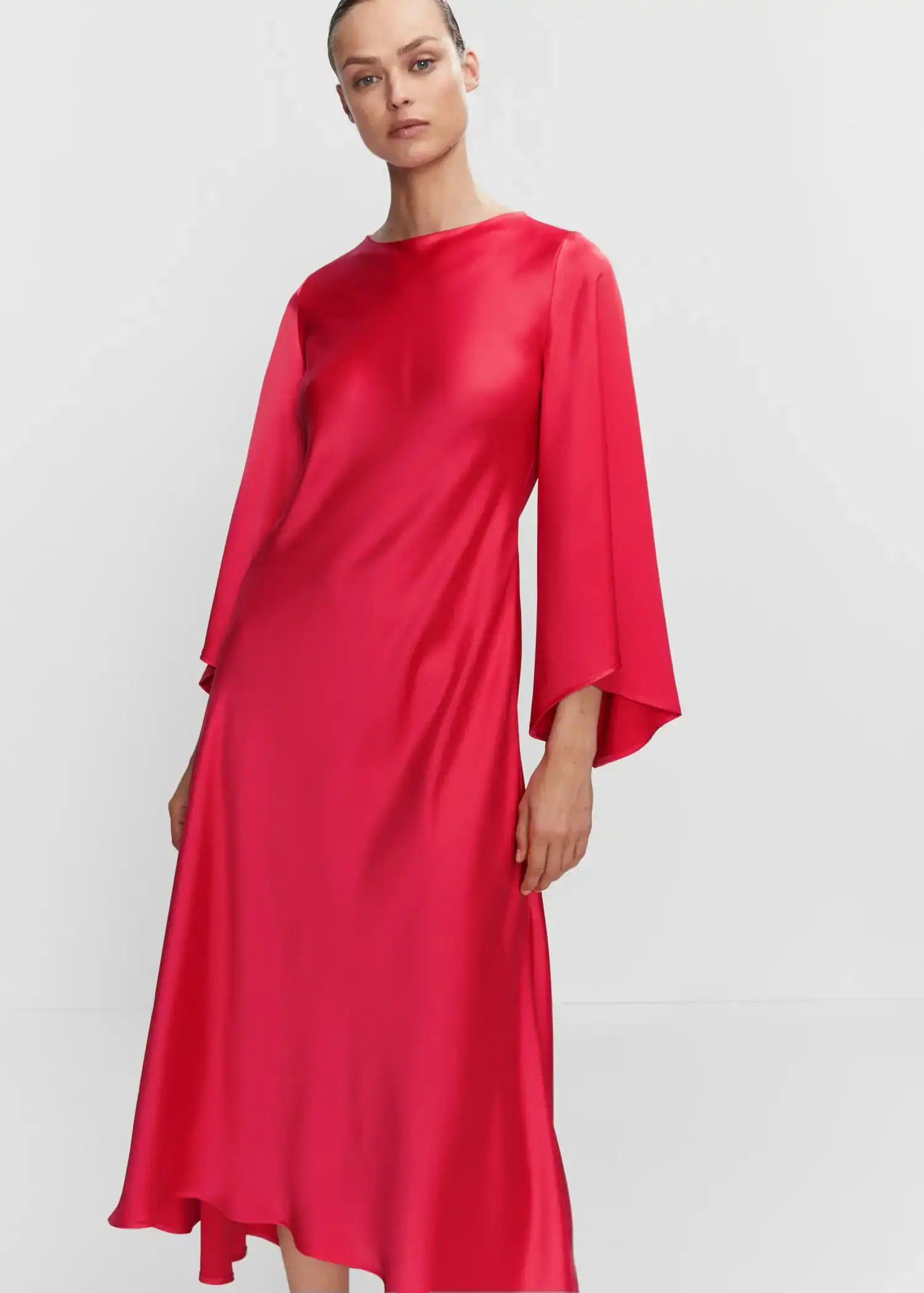 Mango Flared-sleeve satin dress. a woman wearing a red dress standing next to a white wall. 
