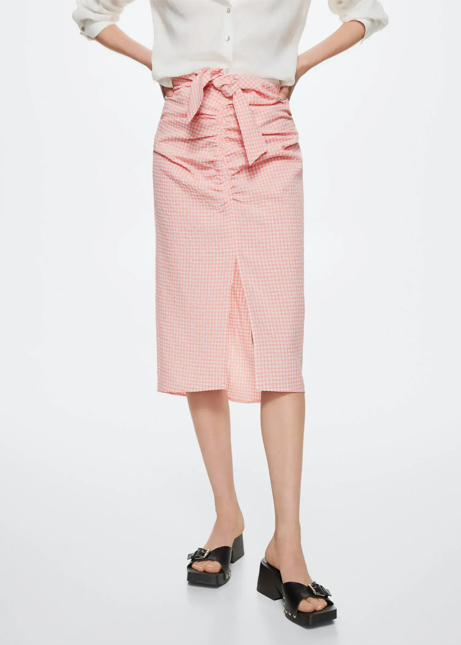 Mango Gingham pleated skirt. a woman wearing a pink skirt and black shoes. 