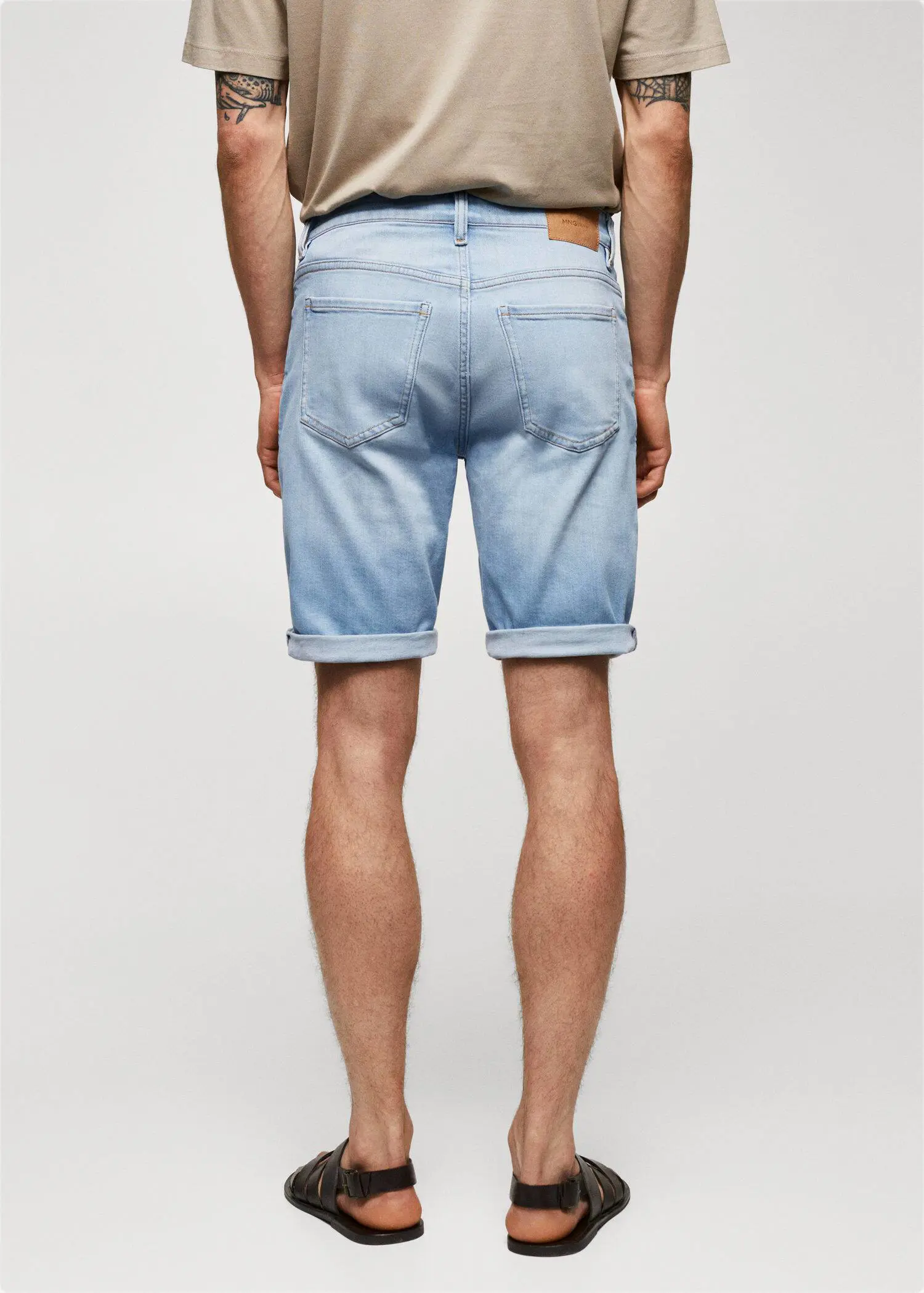 Mango Slim-fit denim bermuda shorts. a man wearing light blue shorts and a white shirt. 