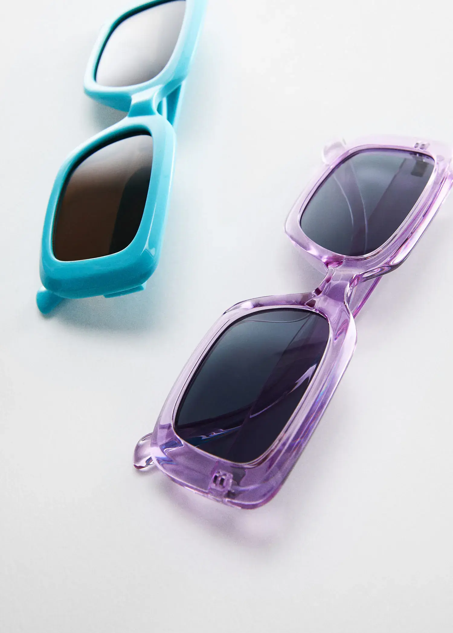 Mango Rectangular sunglasses. two pairs of sunglasses sitting next to each other on a table. 