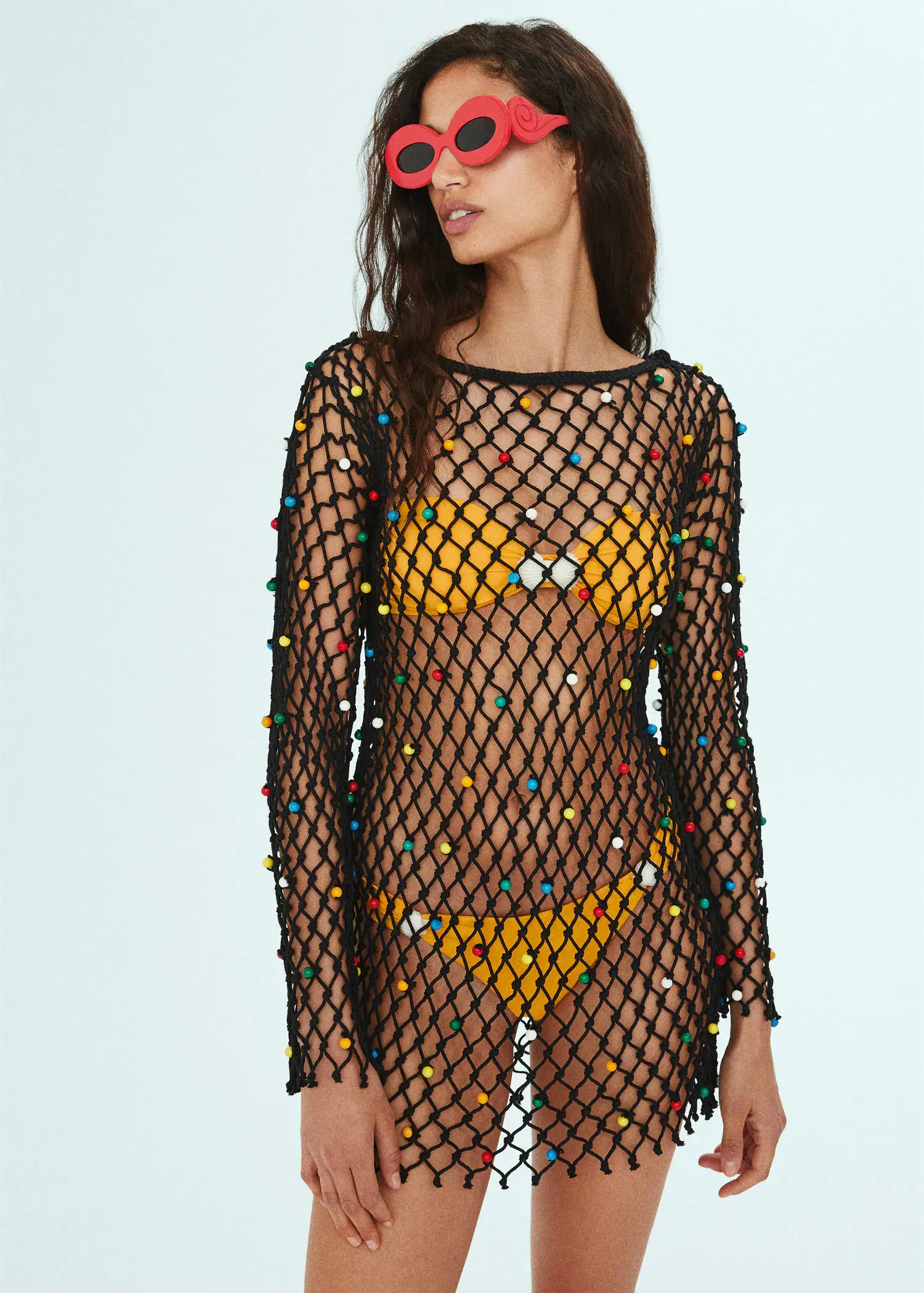 Mango Mesh dress with bead detail. a woman in a see through dress with colorful beads. 