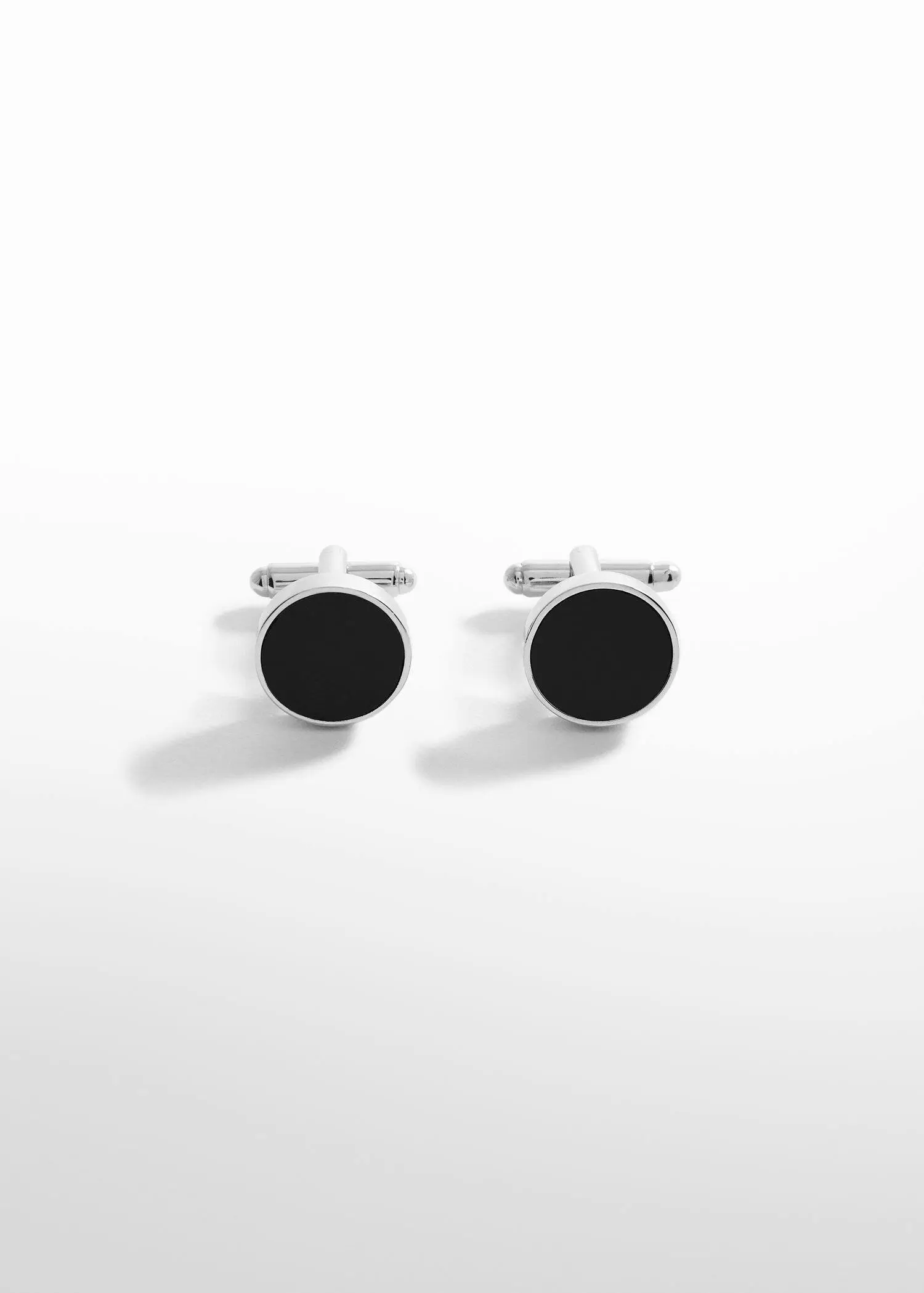 Mango Round black cufflinks. a close up of a pair of cufflinks on a table 