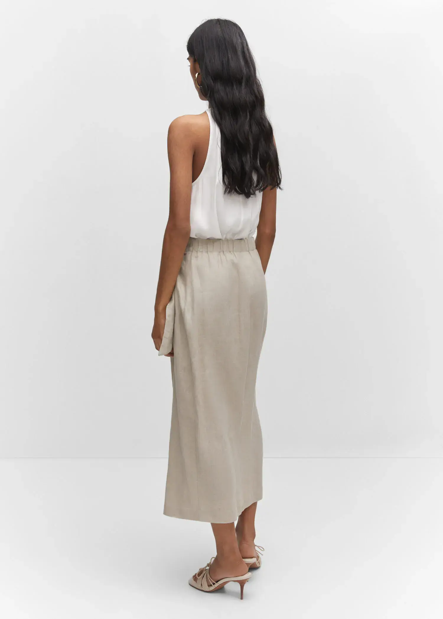 Mango Satin halter-neck top. a woman wearing a white top and a beige skirt. 