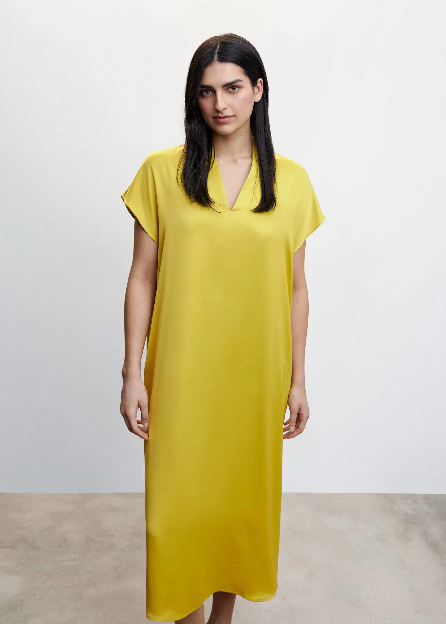 Mango Side-slit satin dress. a woman wearing a yellow dress standing in a room. 