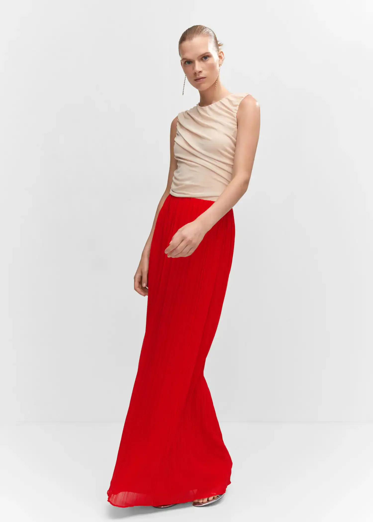 Mango Pleated long skirt. a woman in a red skirt and beige top. 