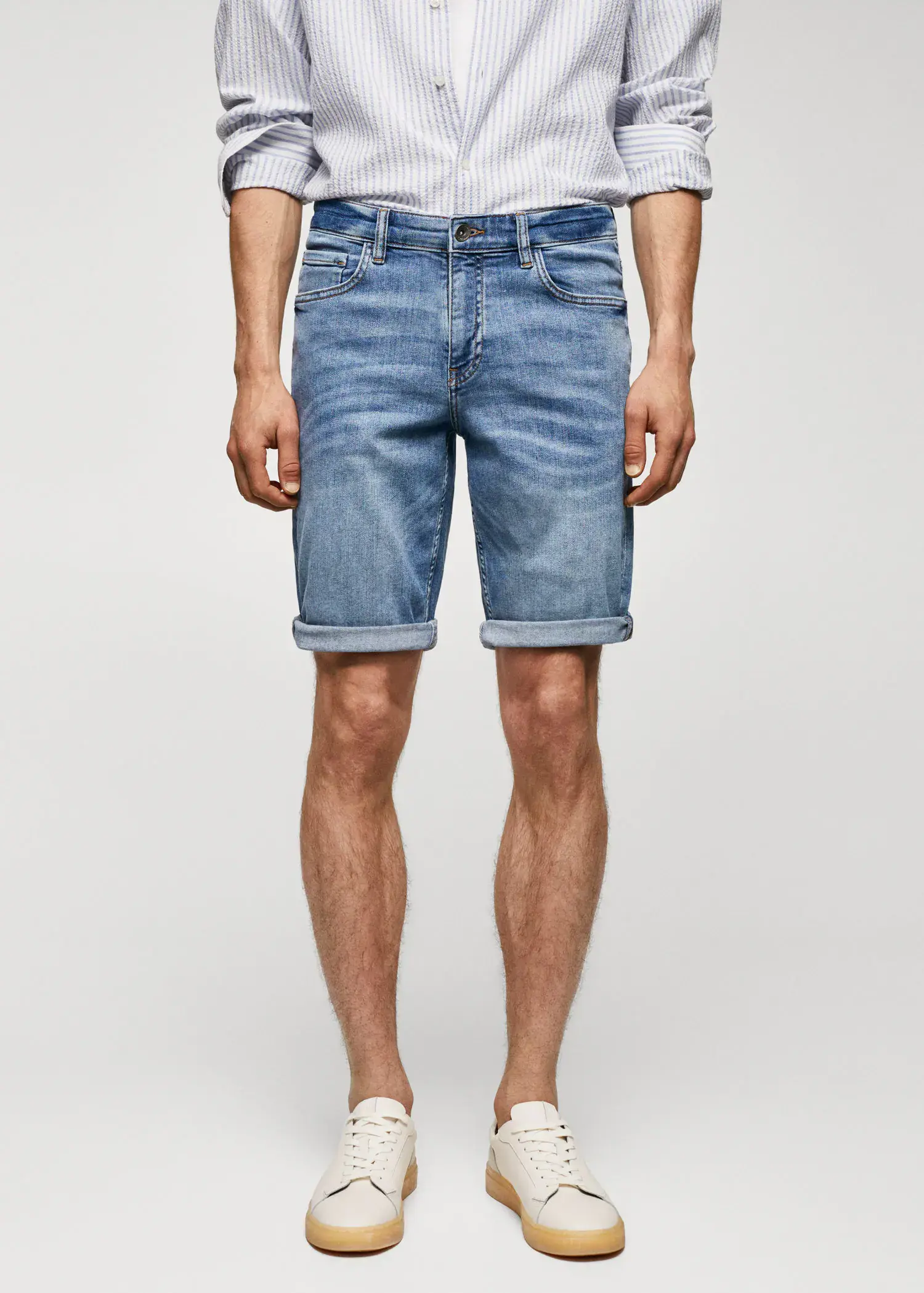 Mango Slim-fit denim bermuda shorts. a man wearing a pair of blue denim shorts. 