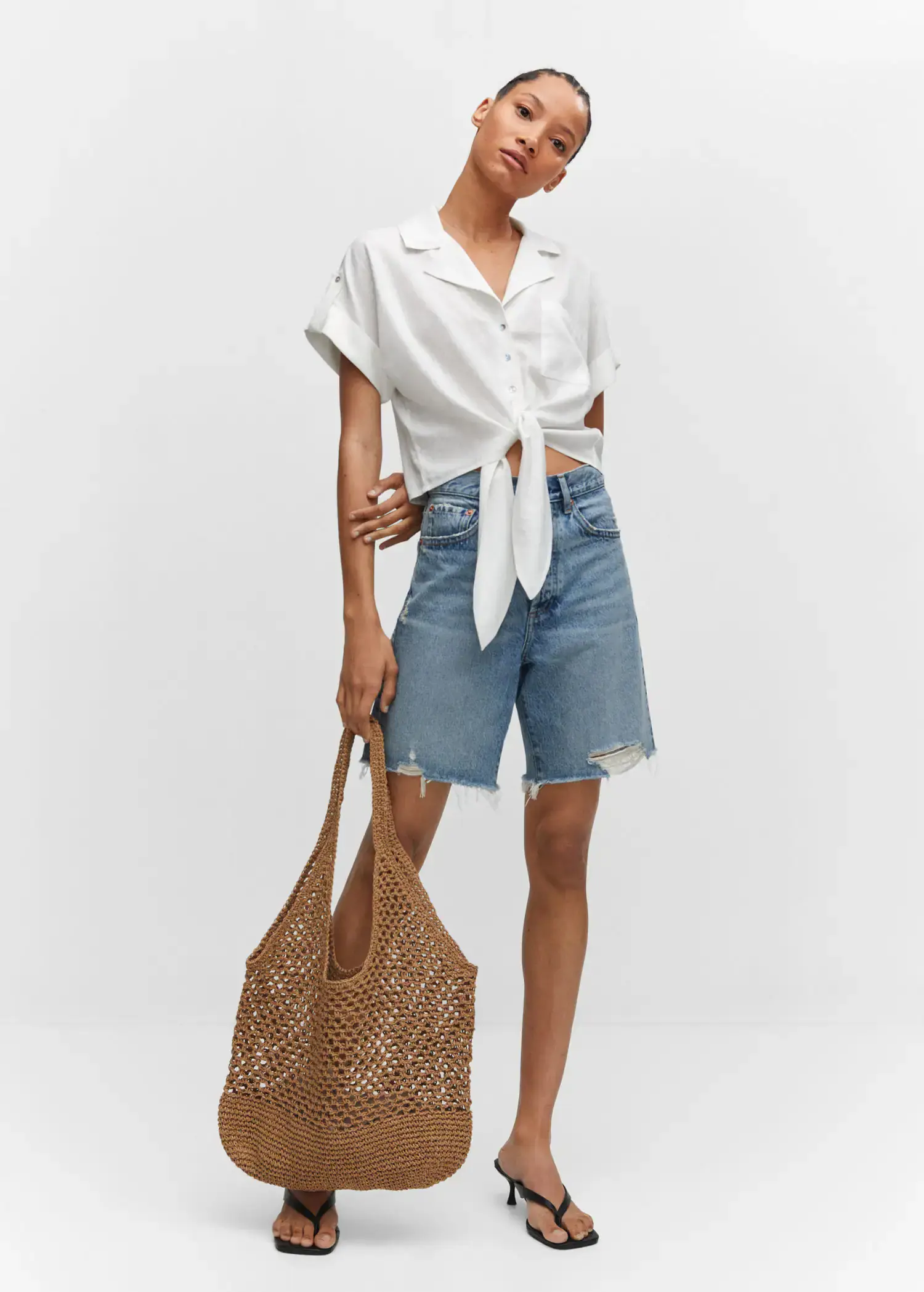 Mango Linen shirt with bow. a woman in a white shirt and shorts holding a bag 