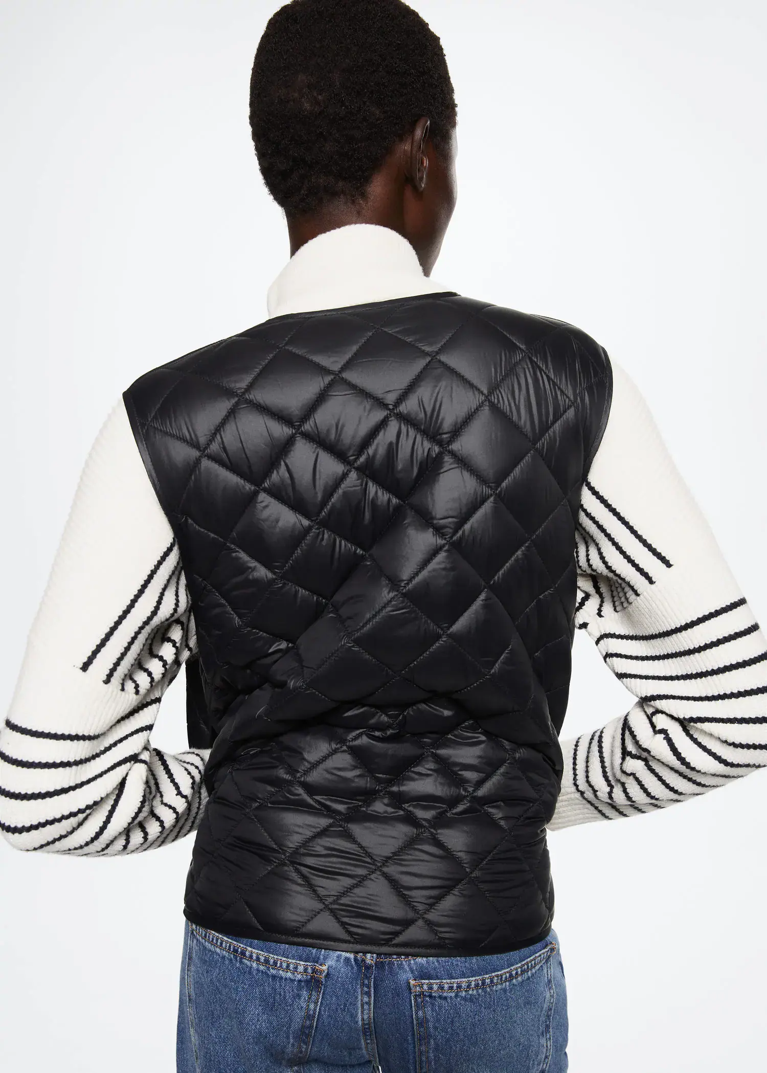 Mango Ultra-light quilted gilet. a person wearing a black and white jacket. 