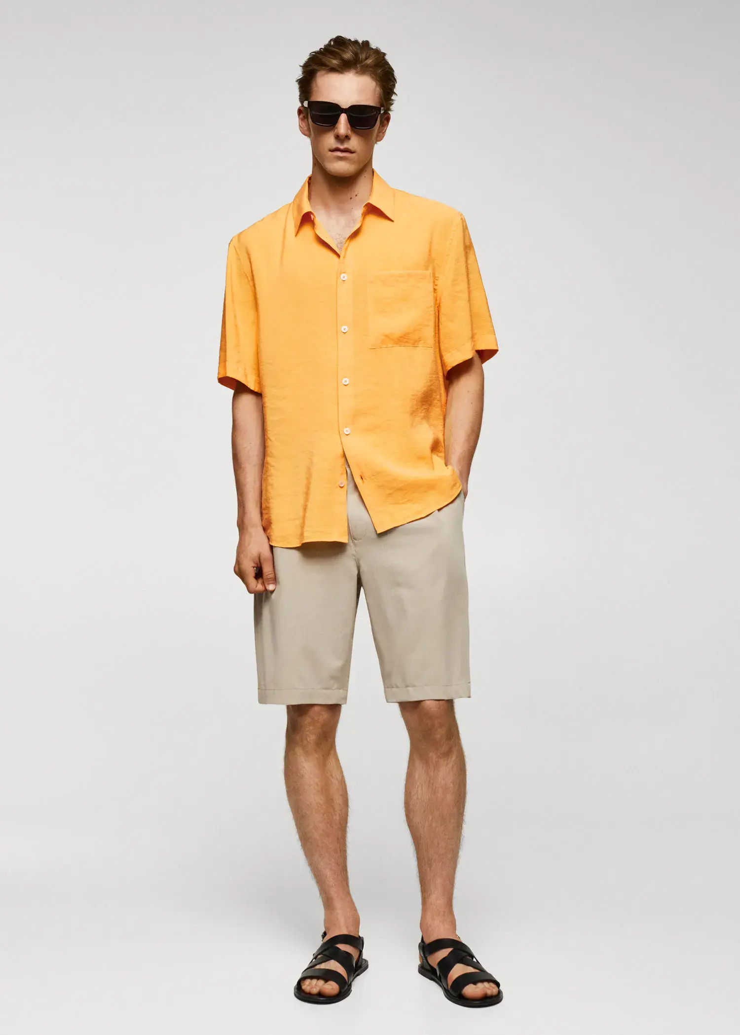 Mango Regular-fit short-sleeved shirt. a man in a yellow shirt and tan shorts. 
