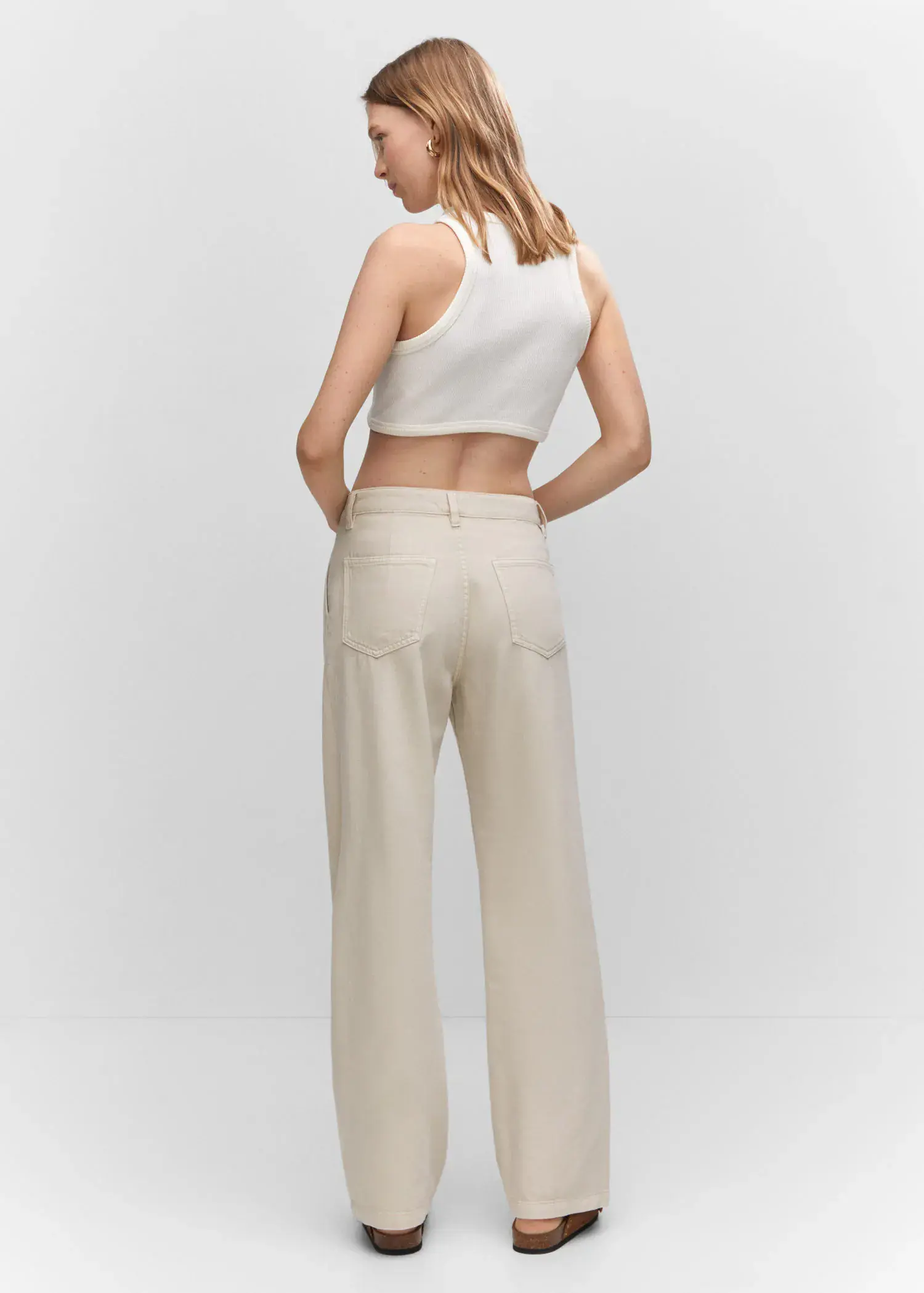 Mango Straight pleated jeans. a woman wearing a white top and white pants. 