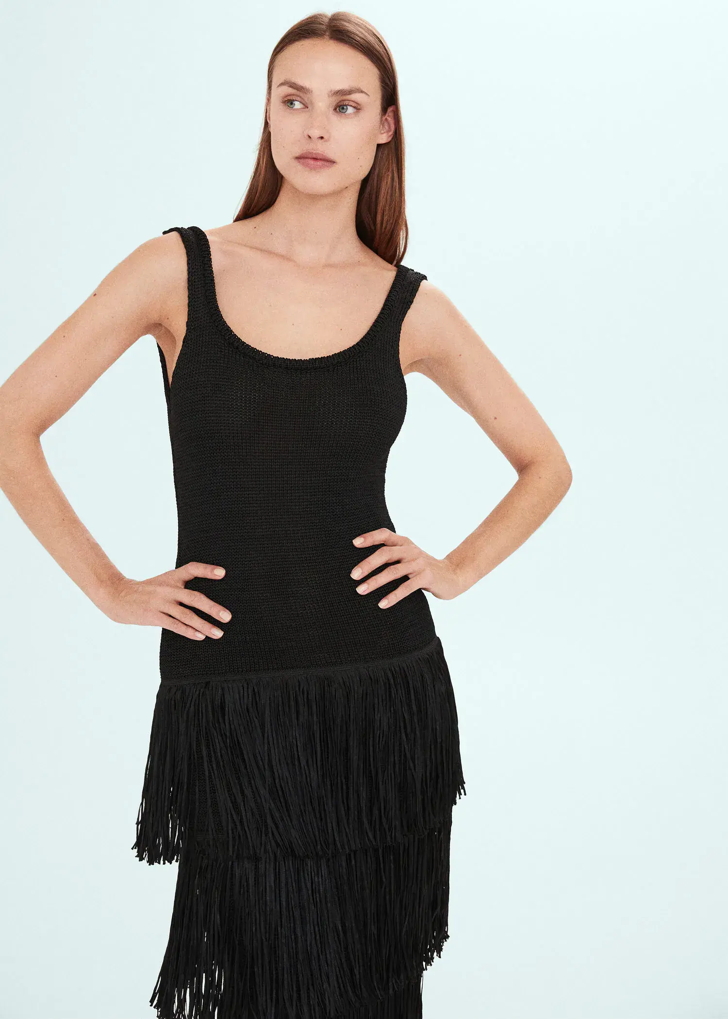 Mango Knitted dress with fringe design. a woman in a little black dress posing for a picture. 