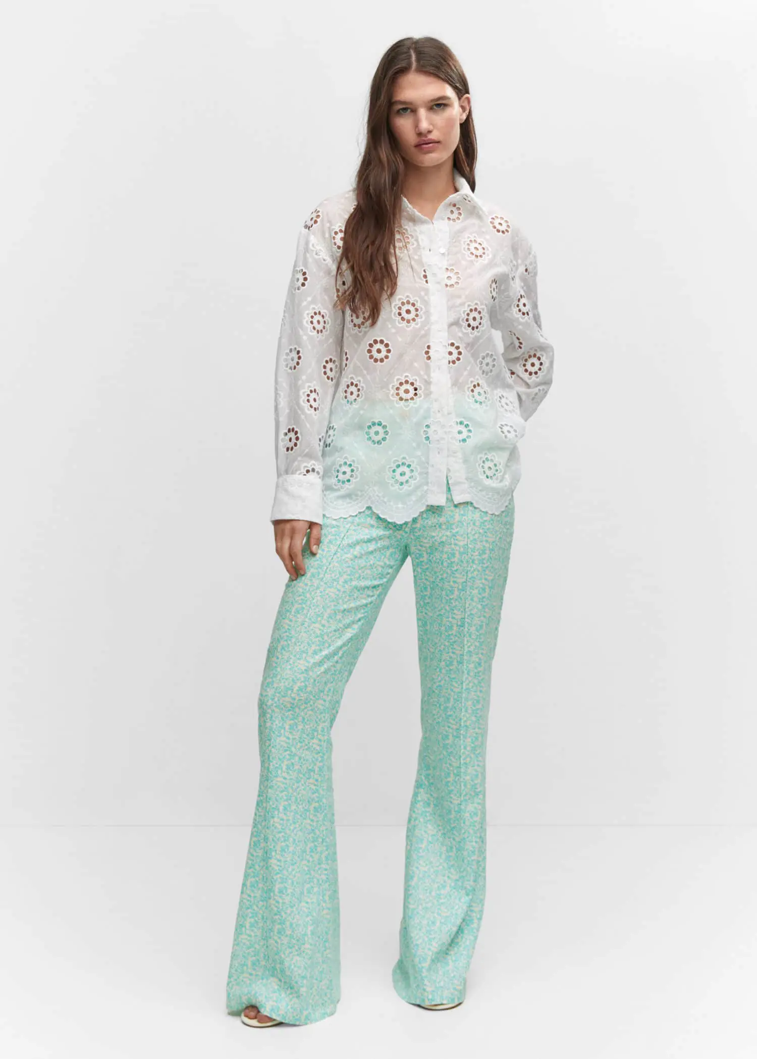 Mango Embroidered openwork shirt. a woman in a white shirt and a light blue pants. 