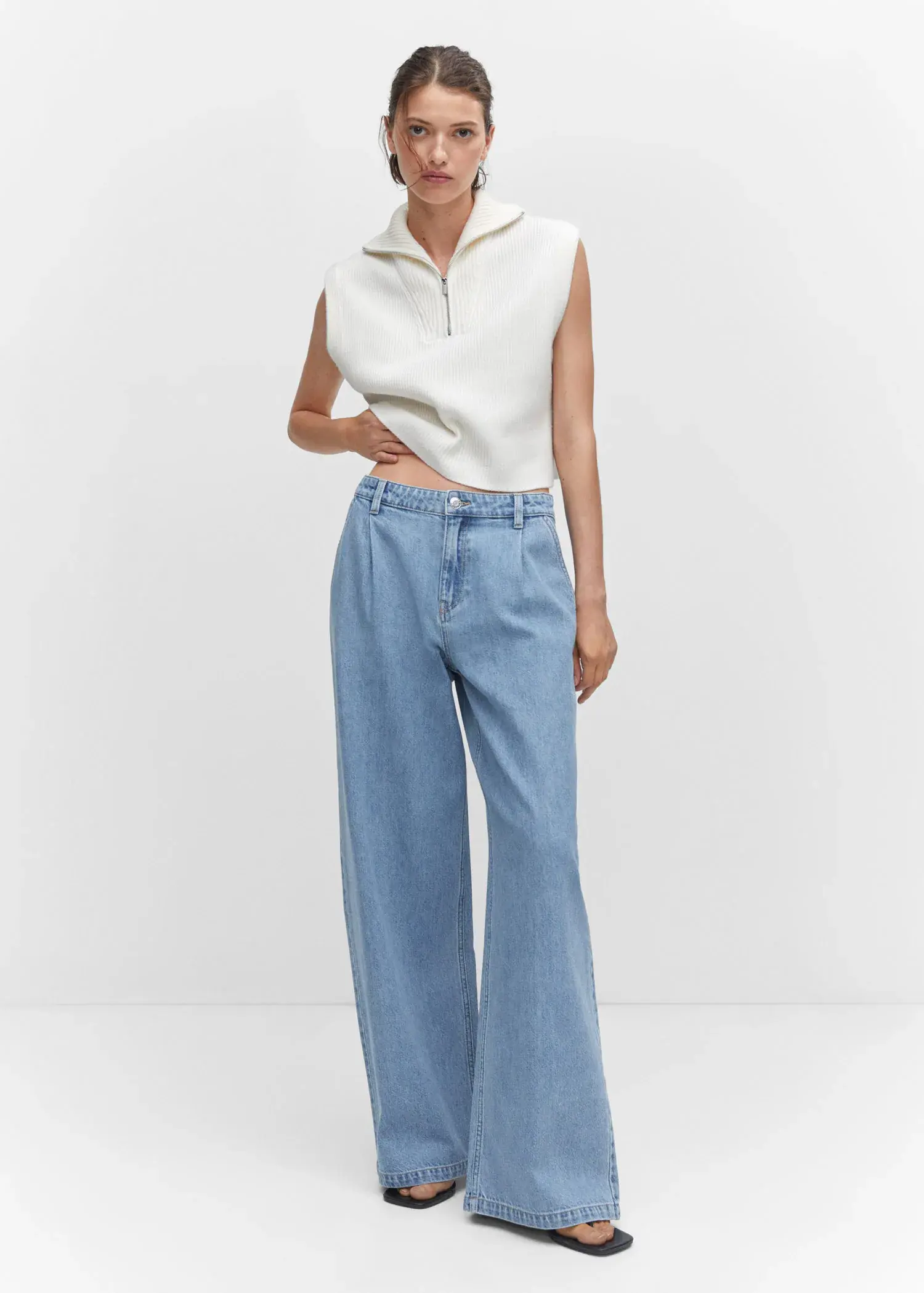 Mango Wide-leg pleated jeans. a woman in a white top and light blue jeans. 
