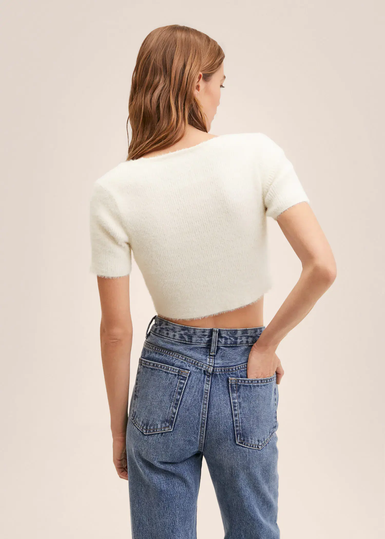 Mango Knitted cropped cardigan. a woman in a white crop top and blue jeans. 