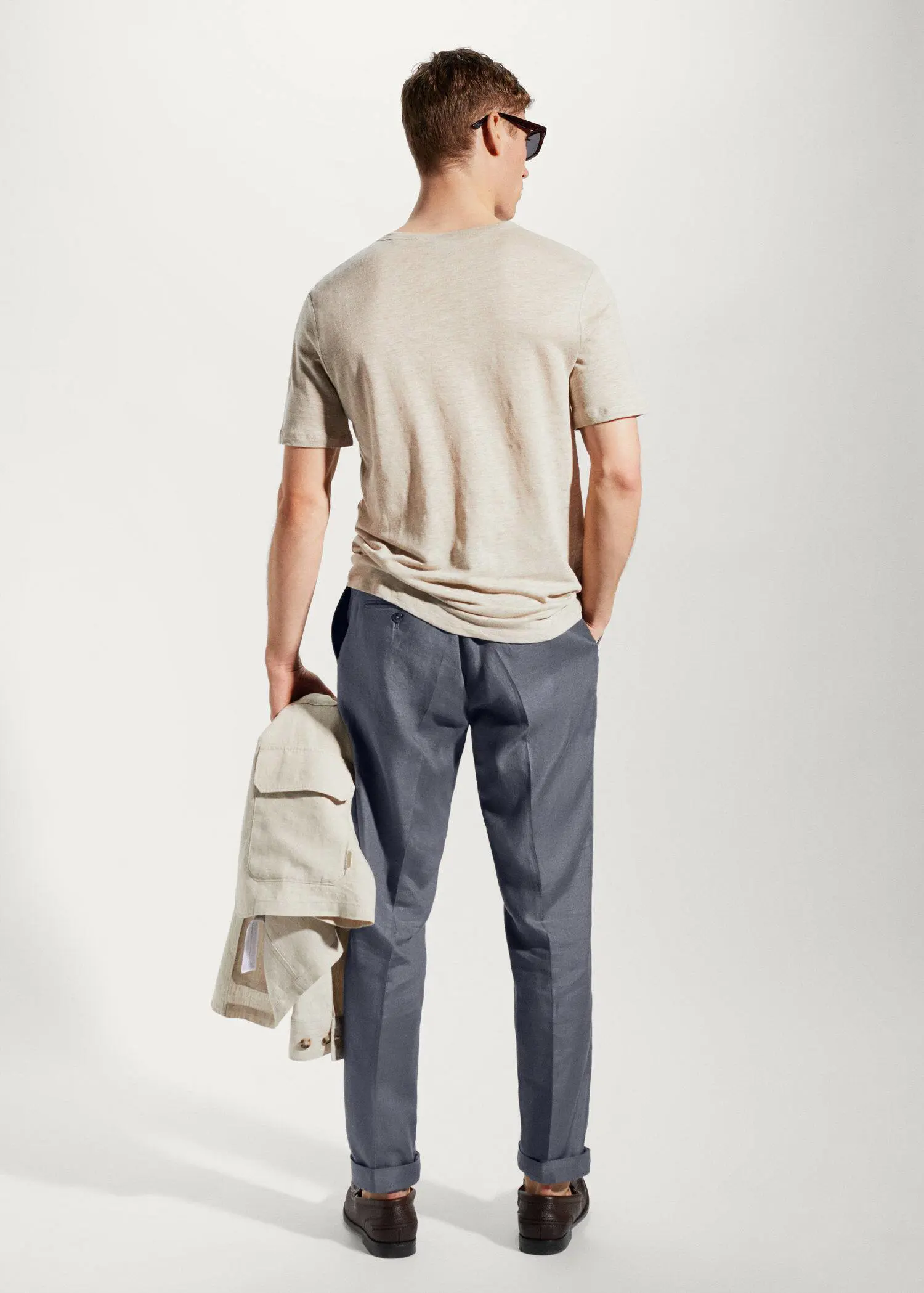 Mango 100% linen Henley t-shirt. a man with a backpack is holding his hands in his pockets. 