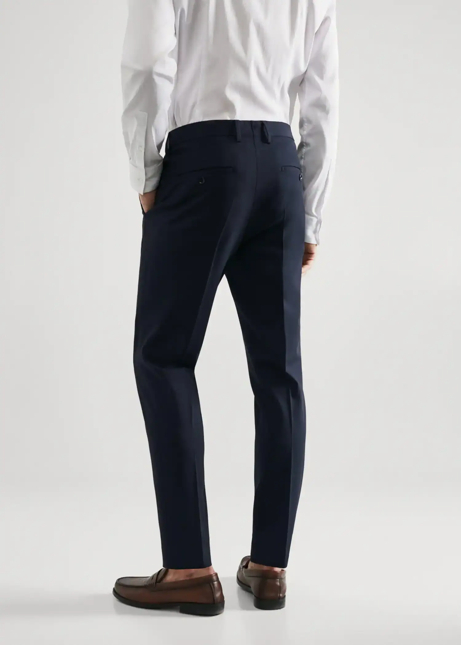 Mango Super slim fit suit trousers. a man wearing a suit and tie standing in front of a white wall. 
