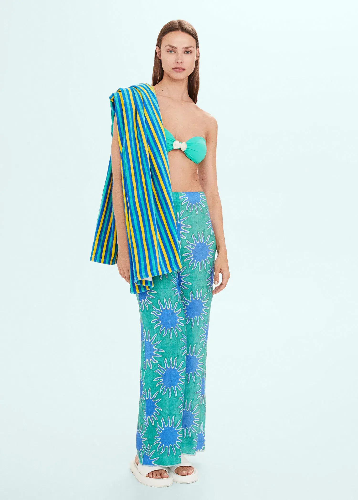 Mango Multi-colored striped beach towel. a woman standing in a blue and green outfit. 