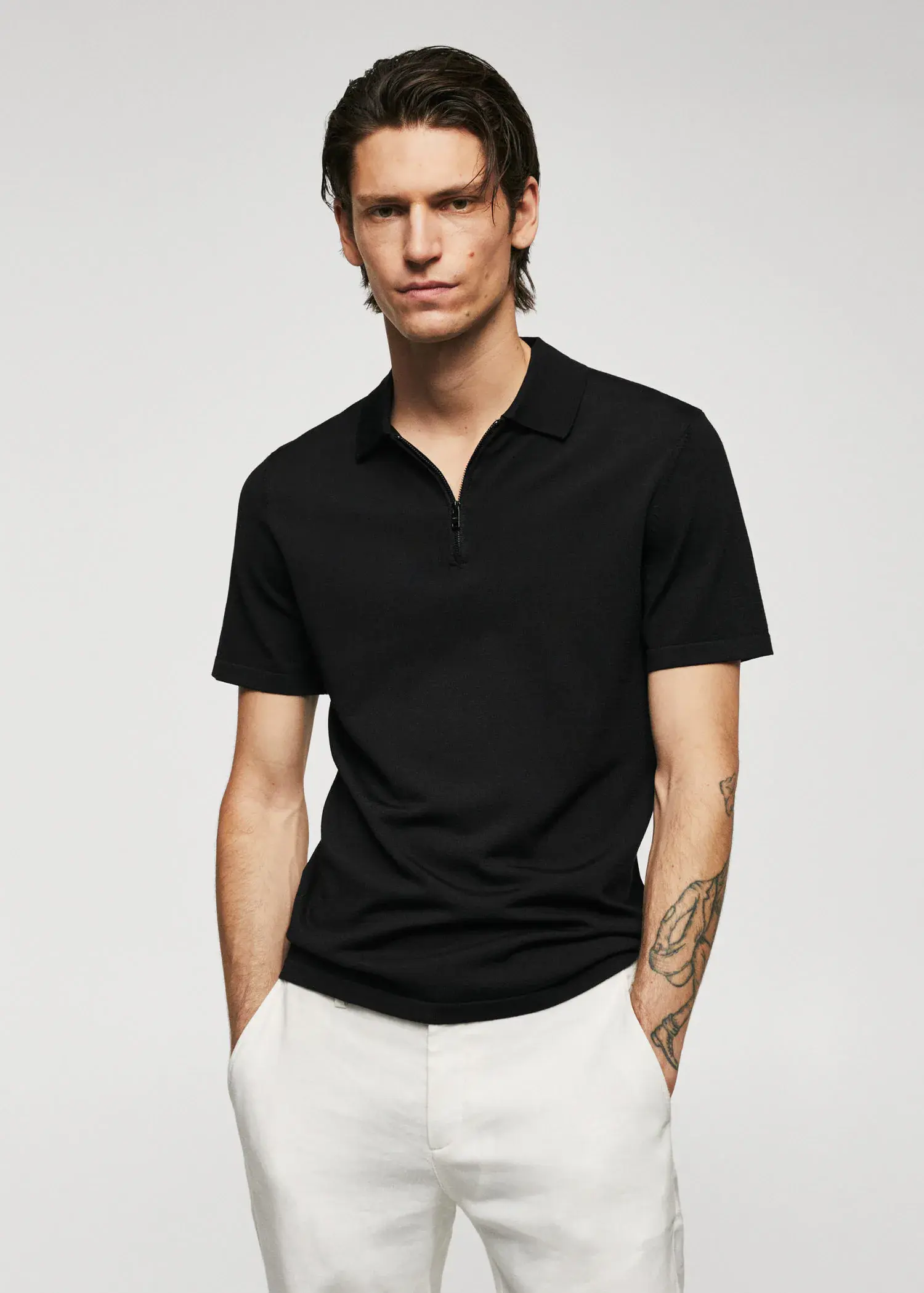 Mango Fine-knit polo shirt with zipper. a man in a black polo shirt and white pants. 
