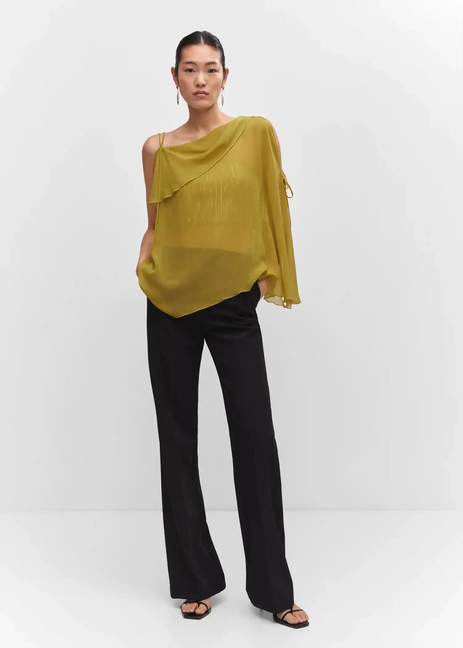 Mango Asymmetrical blouse with bows. a woman wearing a yellow top and black pants. 