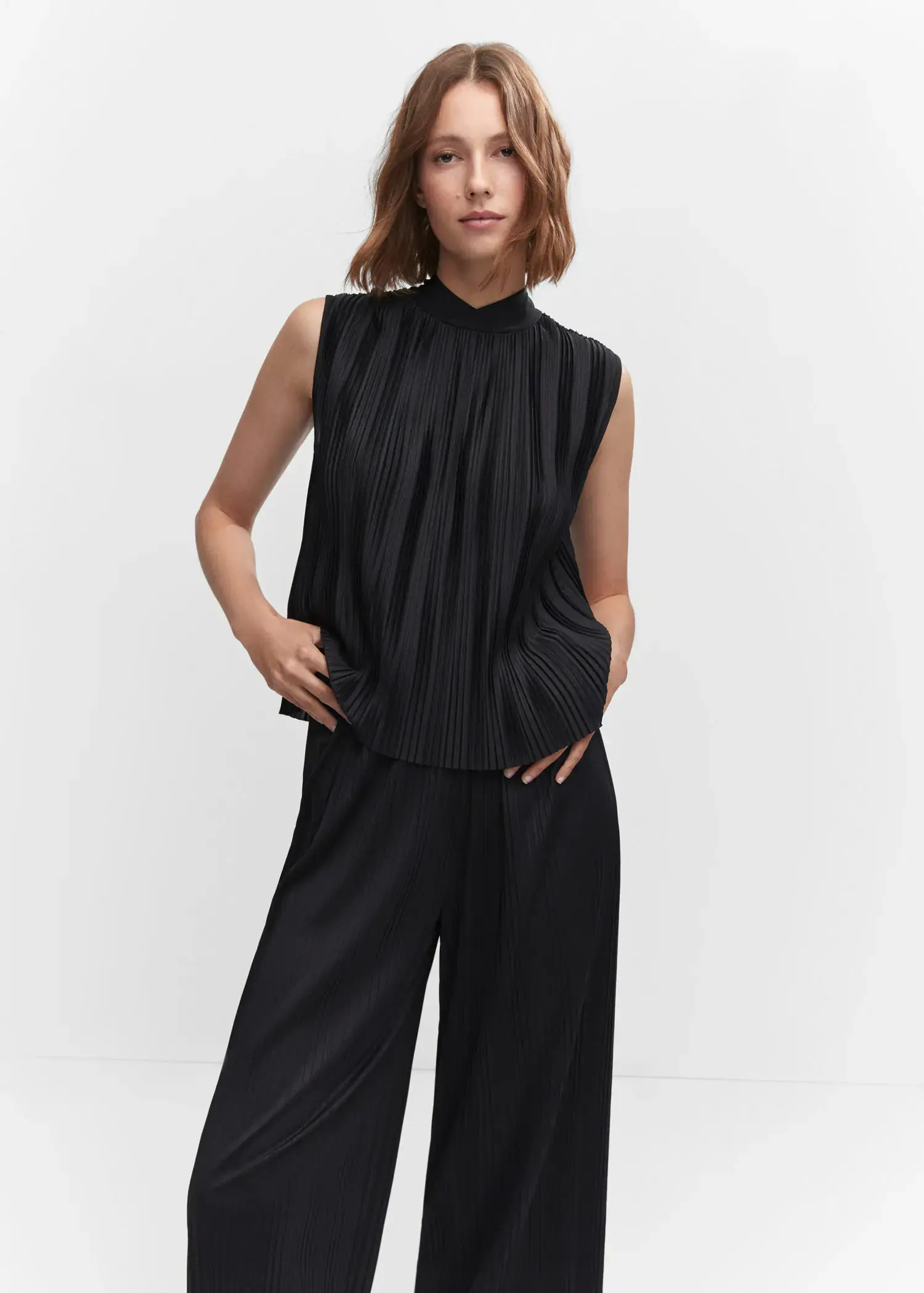 Mango Pleated bow top. a woman in a black outfit posing for a picture. 