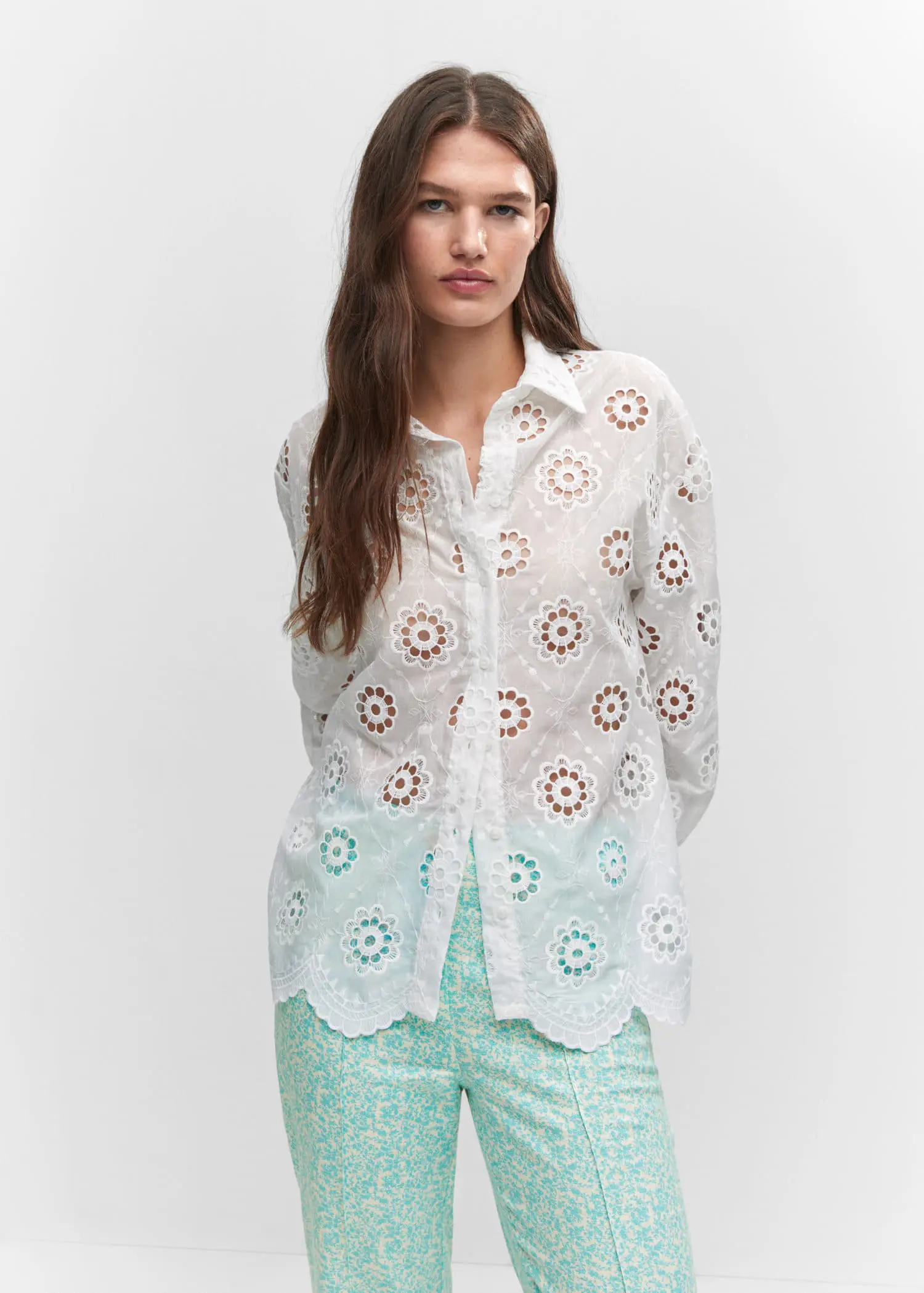 Mango Embroidered openwork shirt. a woman wearing a white shirt and green pants. 