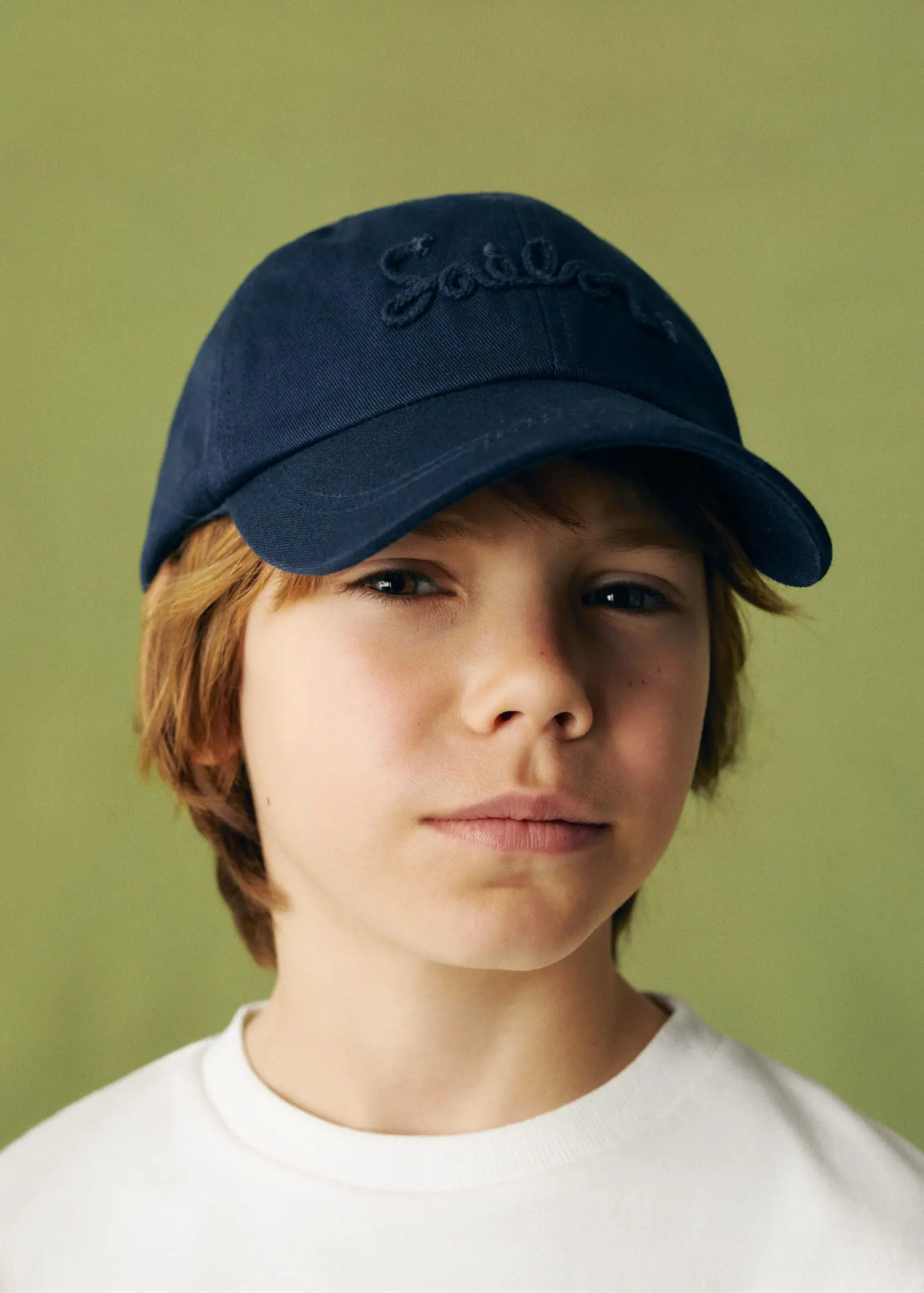 Mango  KIDS/ Embroidered cotton cap. a young boy wearing a baseball cap and white shirt. 