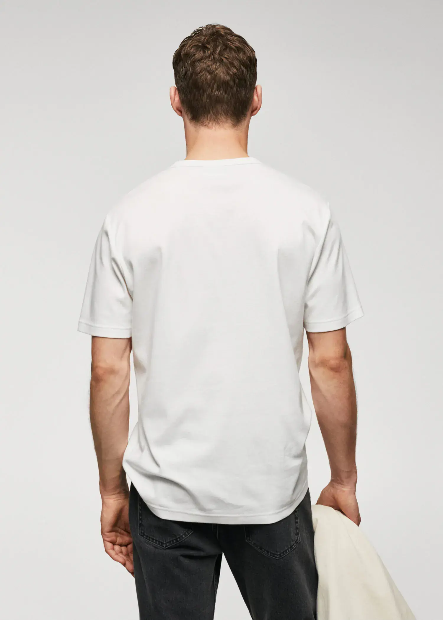 Mango 100% cotton t-shirt with pocket. a man in a white shirt is holding his hands behind his back. 