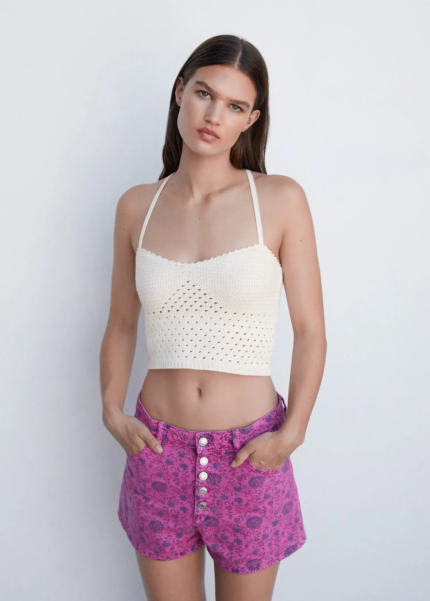 Mango Openwork details knit top. a woman in a white crop top and a purple skirt. 