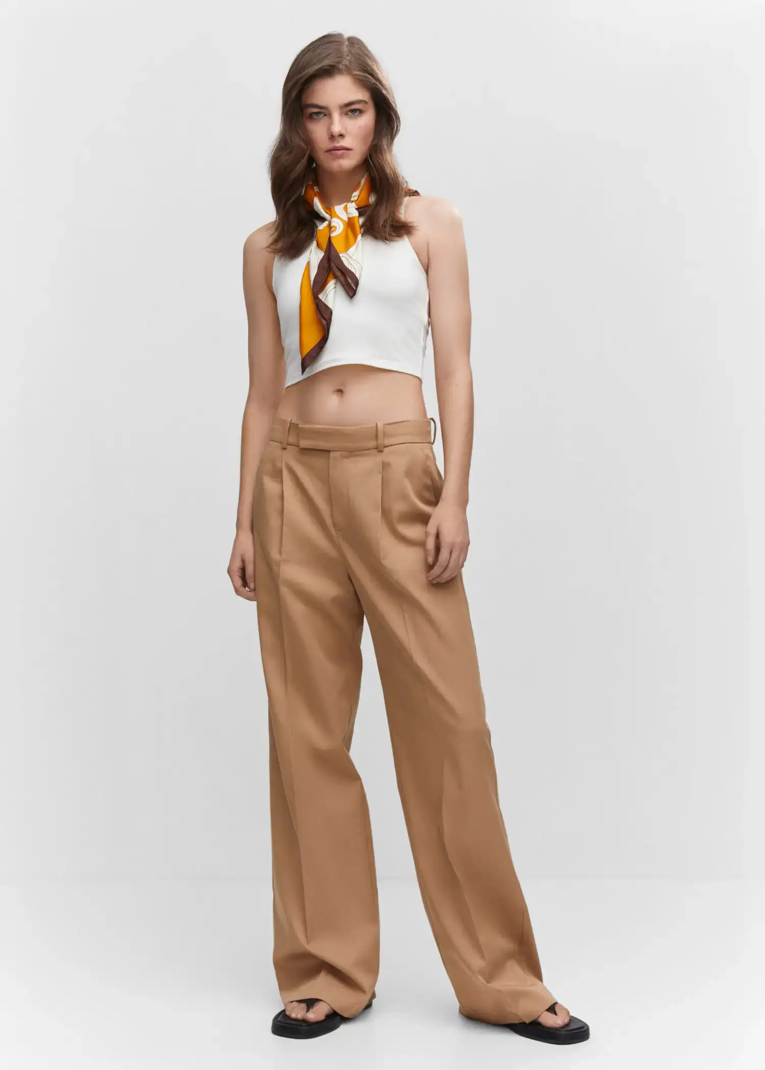 Mango Crop top halter neck. a woman in a white top and brown pants. 