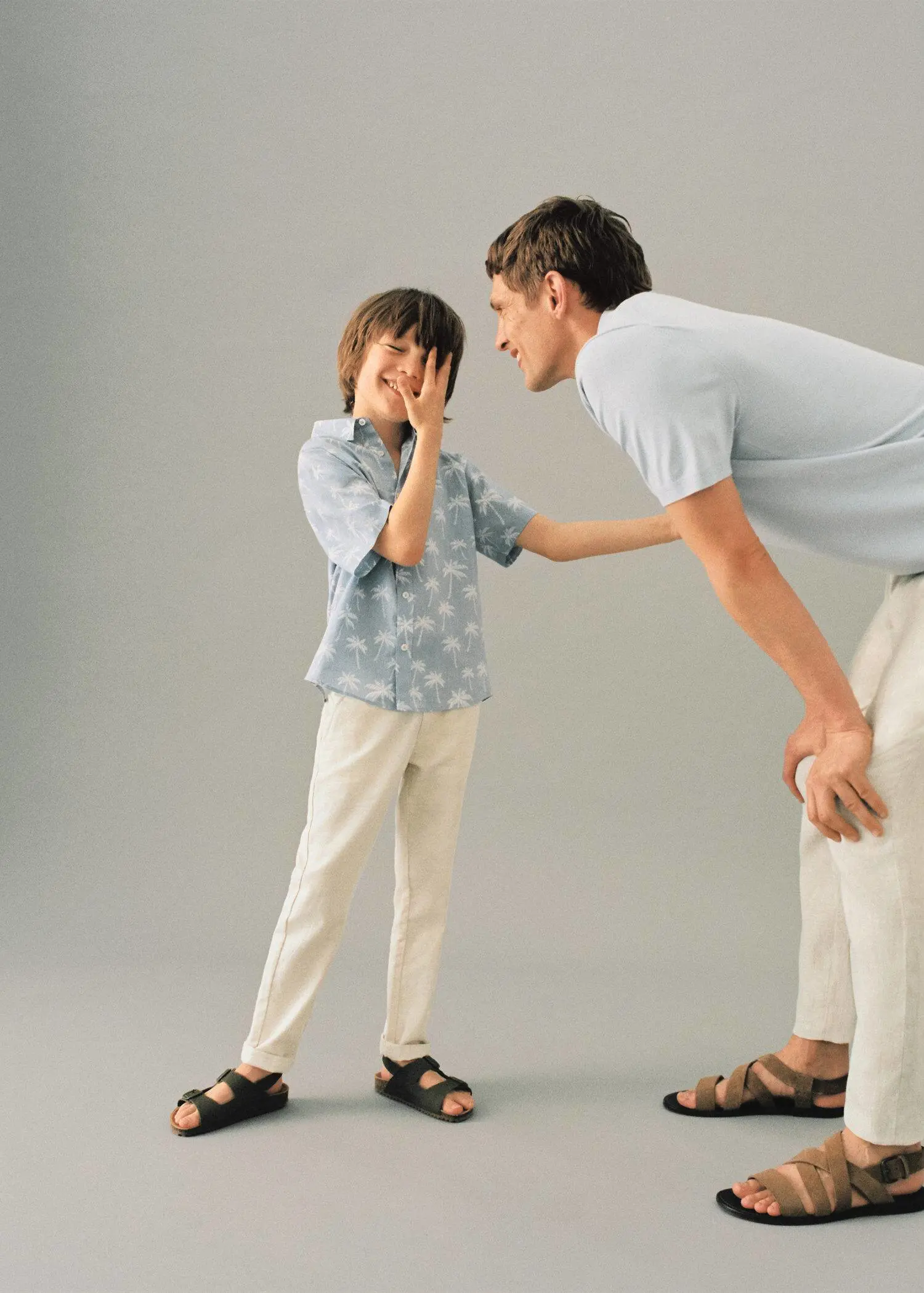 Mango KIDS/ Linen chinos. a man and a boy are playing with each other. 