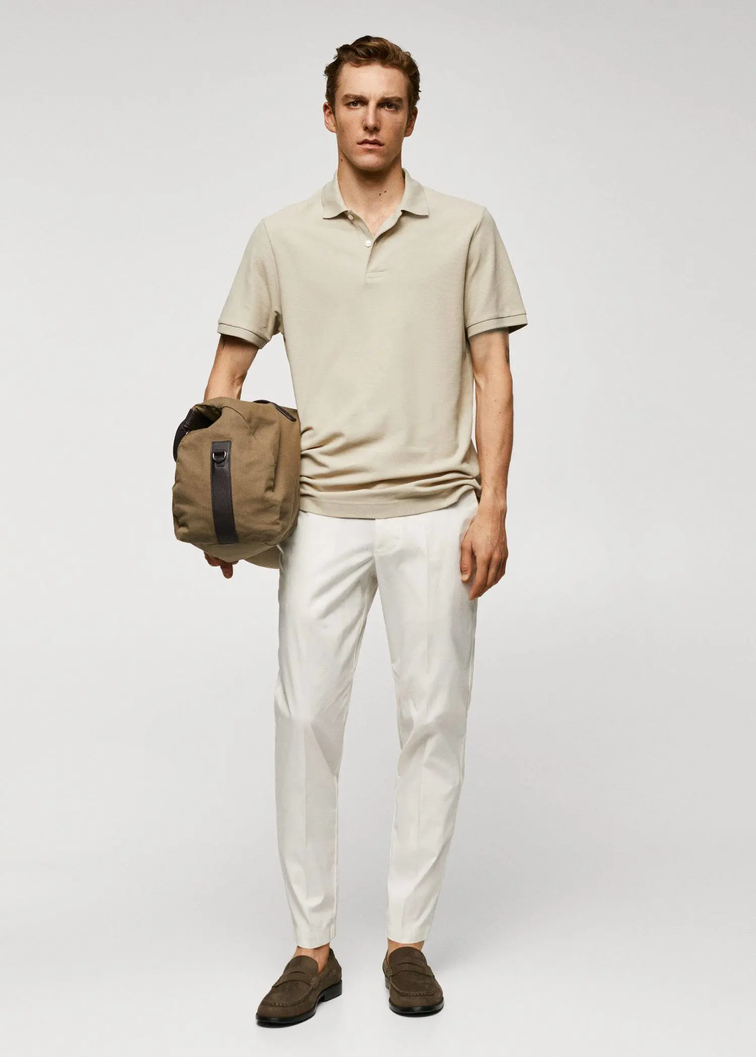 Mango 100% cotton pique polo shirt. a man in a tan polo shirt holding a bag. 