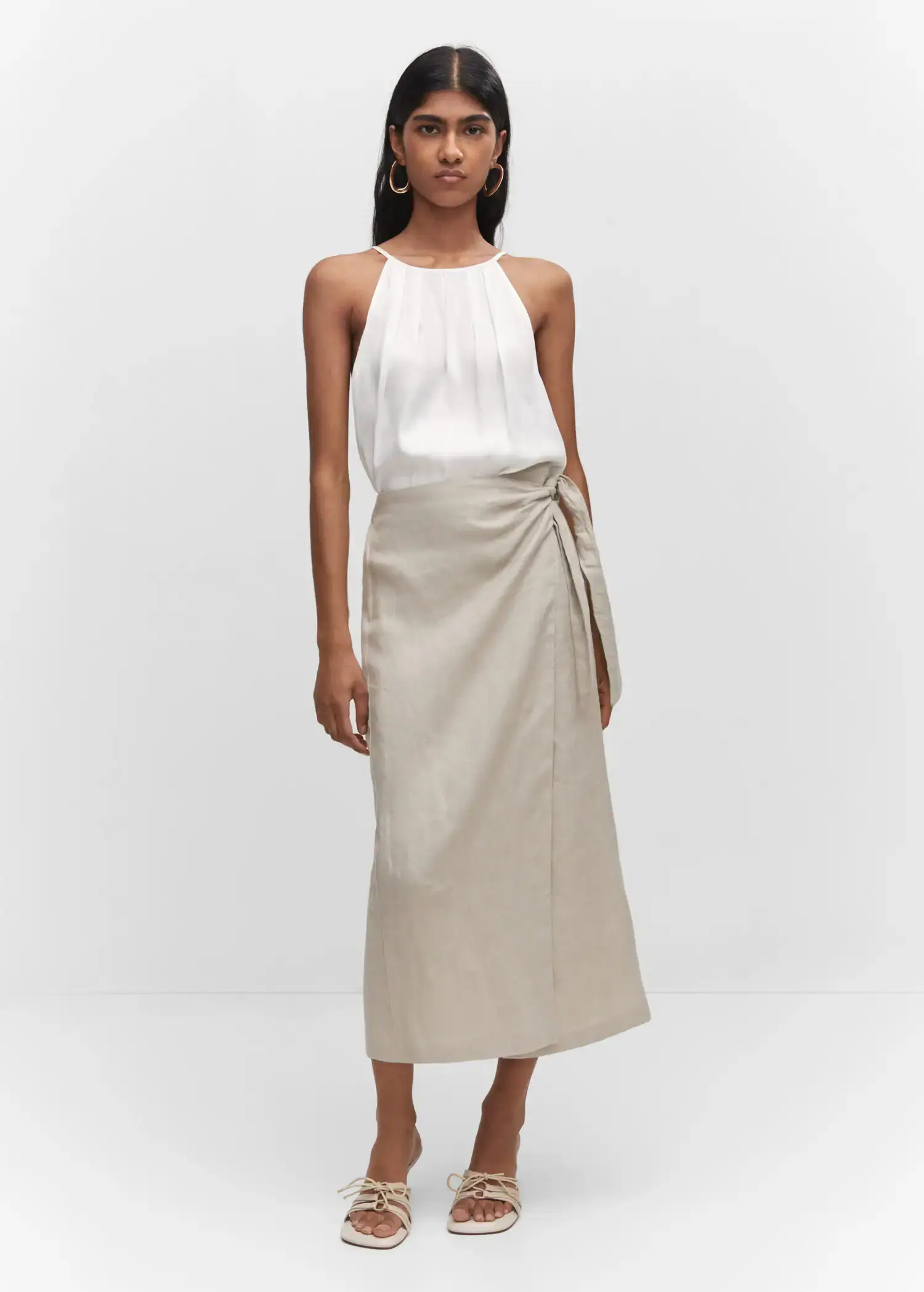 Mango Satin halter-neck top. a woman wearing a white top and a beige skirt. 