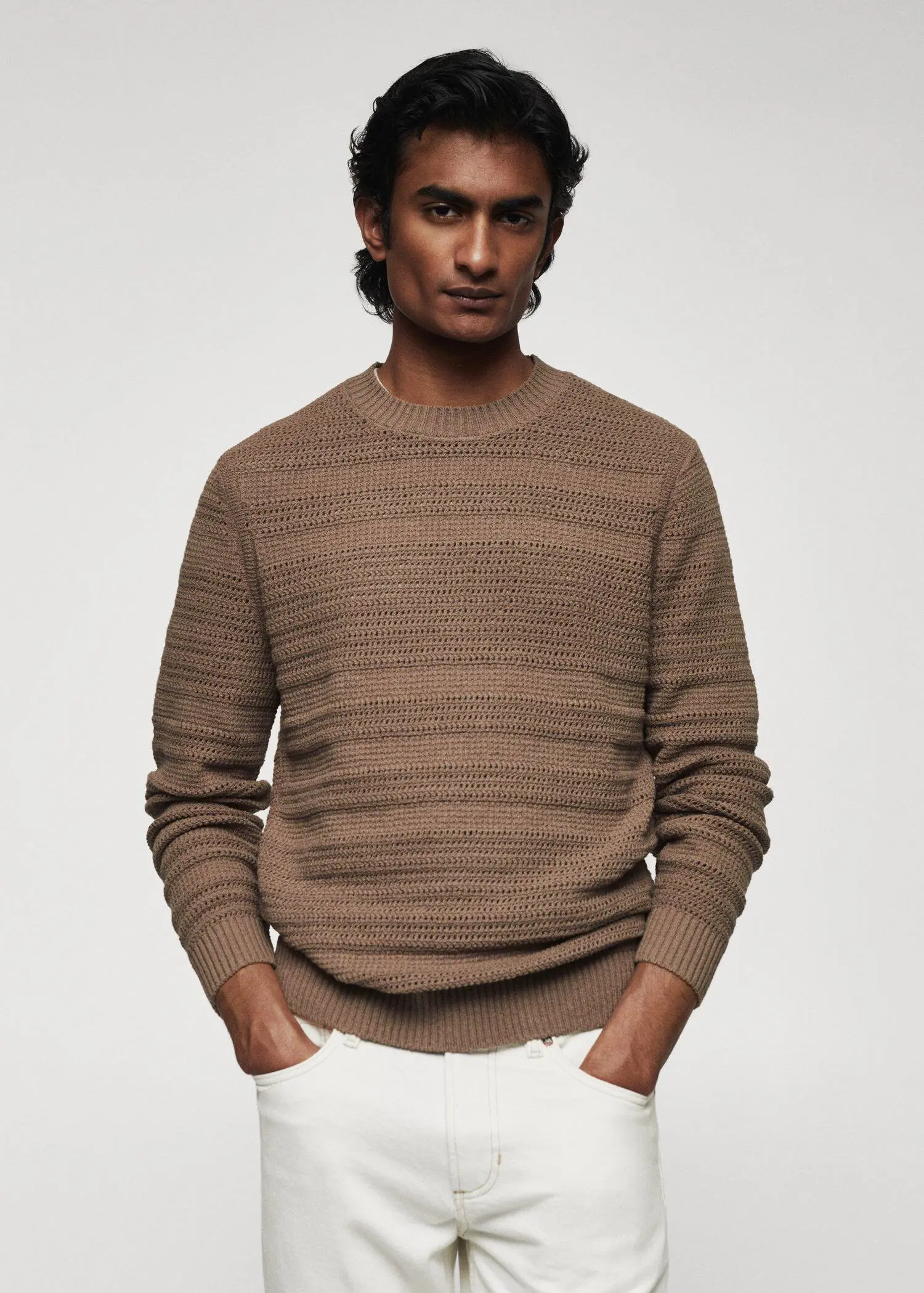 Mango Openwork cotton sweater. a man wearing a brown sweater and white pants. 