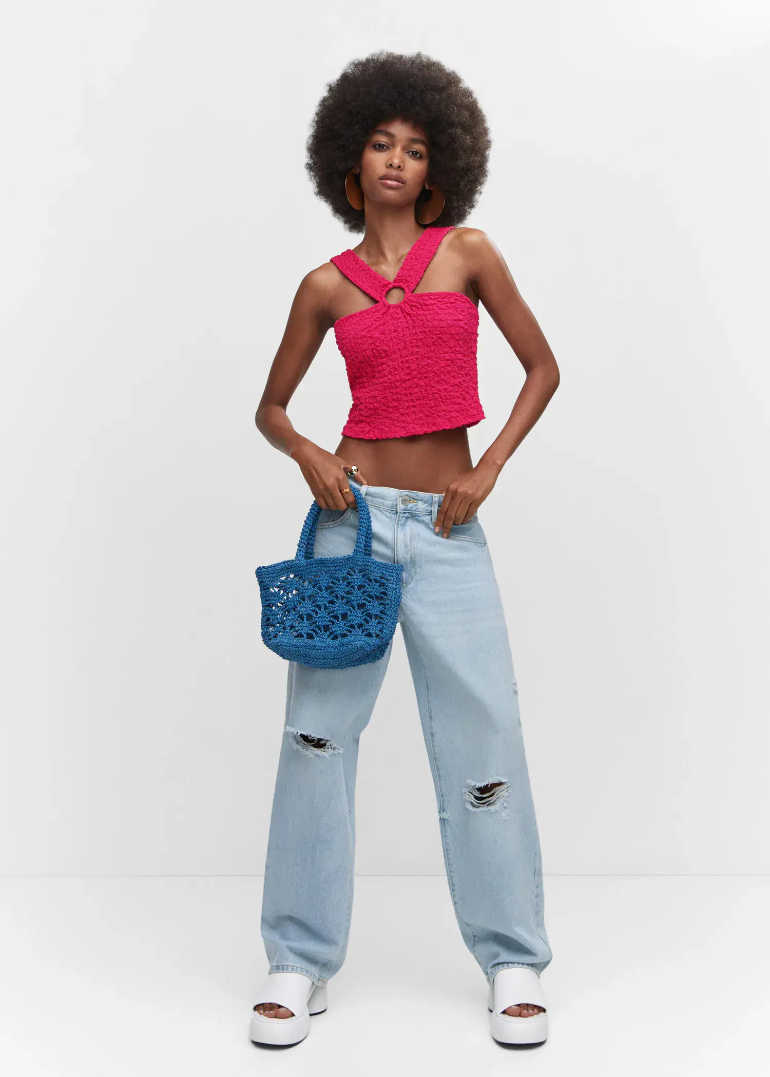 Mango Textured top with ring detail. a woman holding a blue purse in her hands. 