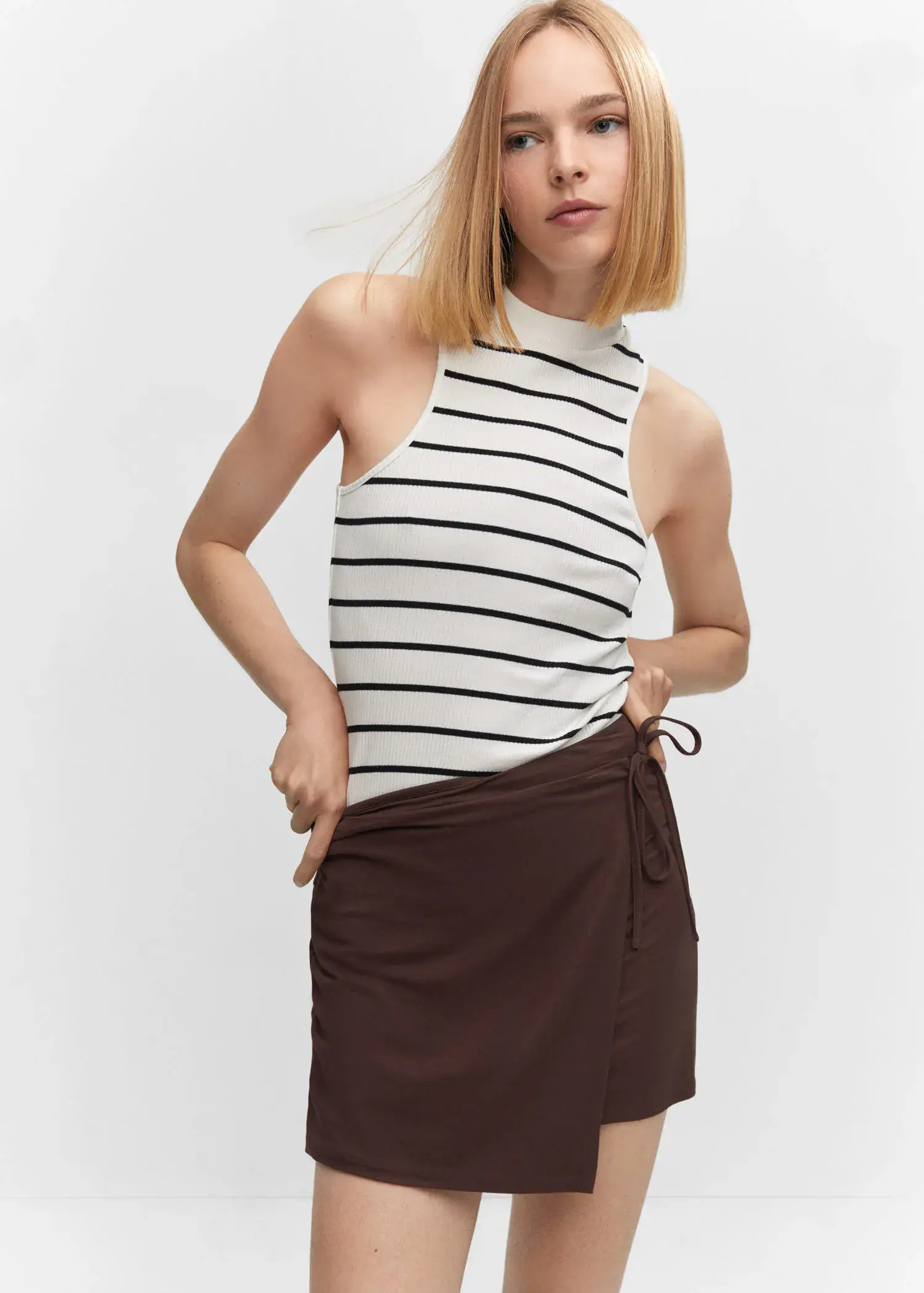 Mango Bow wrap skirt. a woman in a striped top and a brown skirt. 
