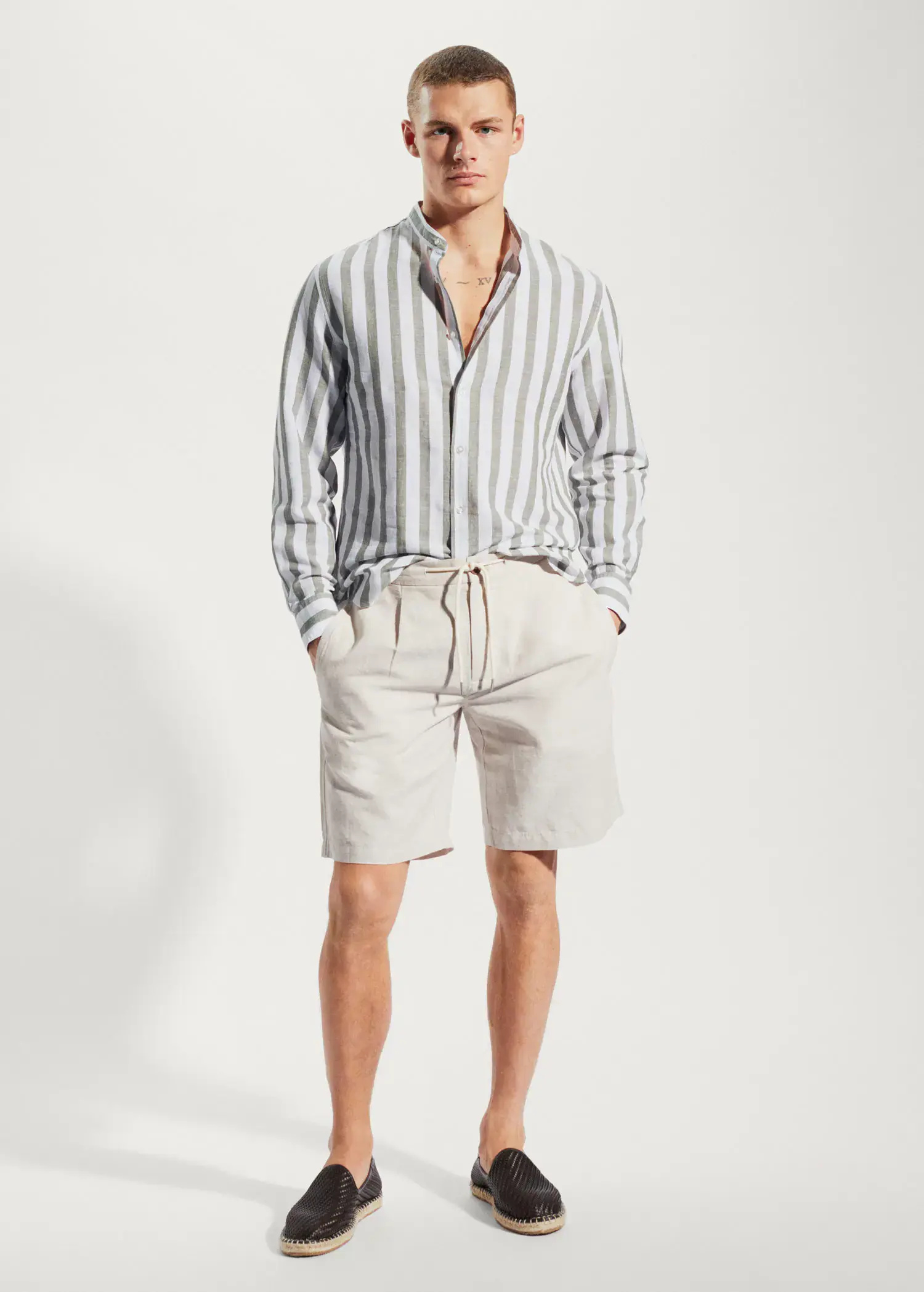 Mango Regular-fit striped linen shirt. a man wearing a striped shirt and shorts. 