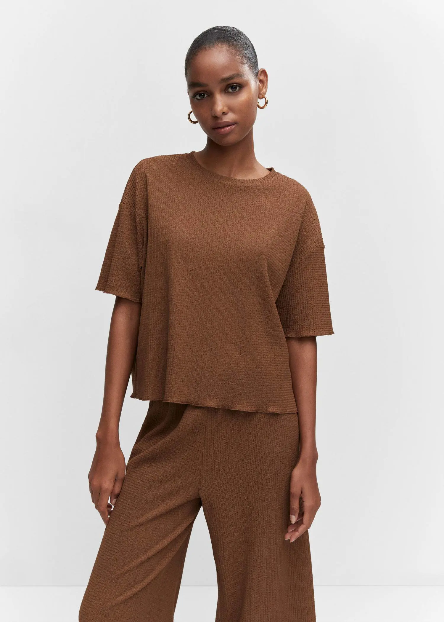 Mango Oversized textured t-shirt. a woman in a brown outfit poses for a picture. 