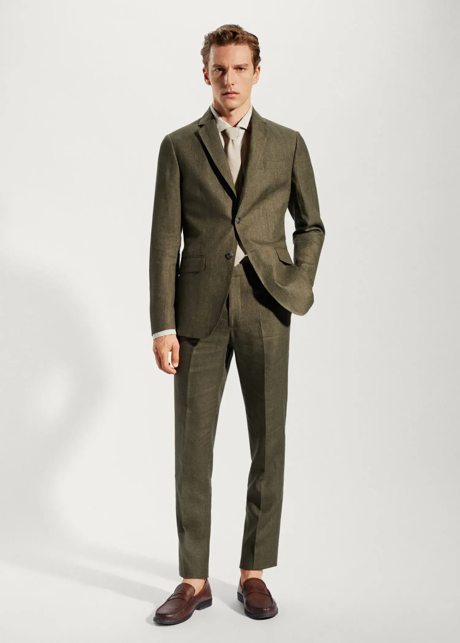Mango 100% linen suit blazer. a man wearing a suit and tie standing next to a wall. 