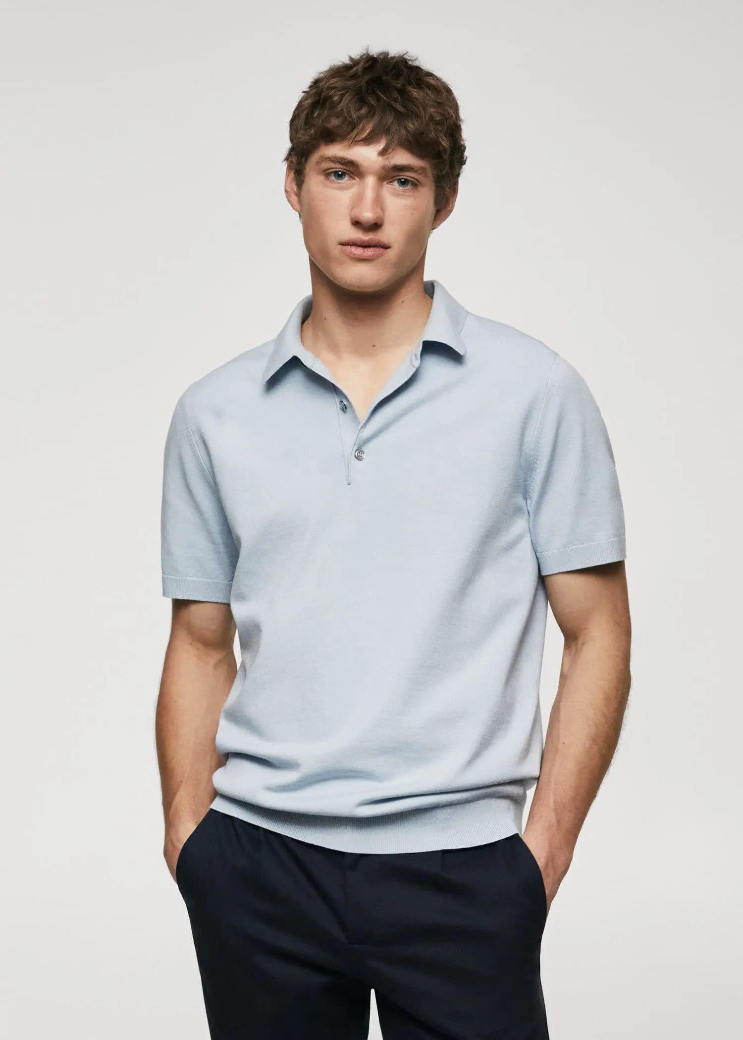 Mango Fine-knit polo shirt. a young man wearing a light blue polo shirt. 