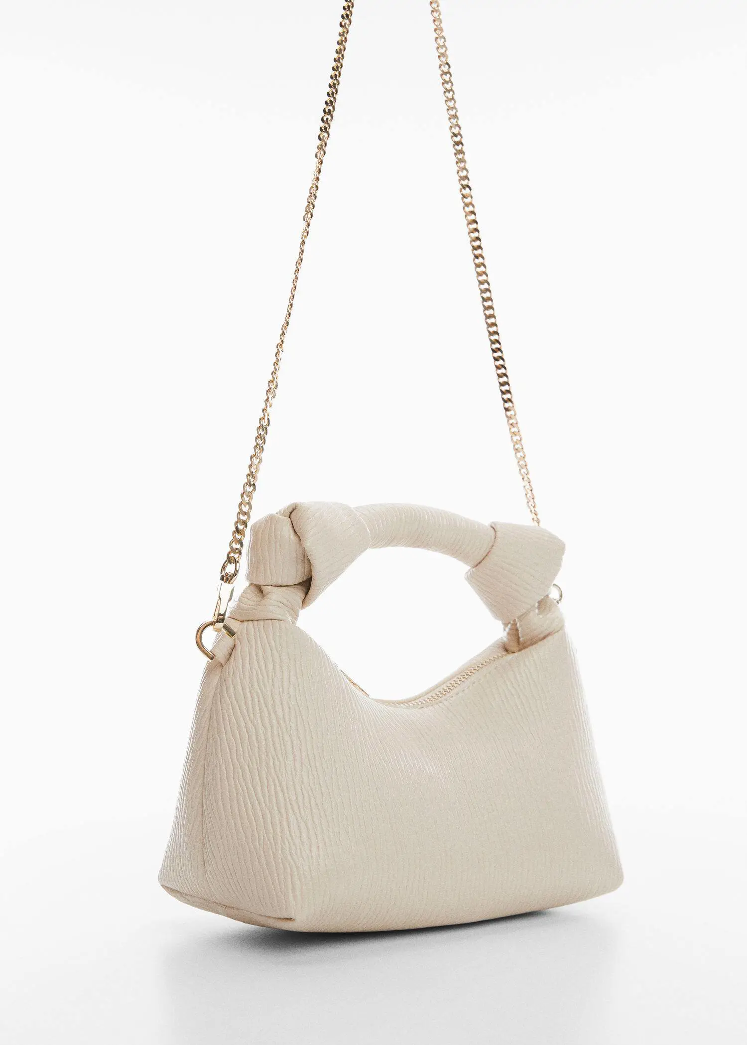 Mango Textured knot handle bag. a close up of a white purse on a white background 