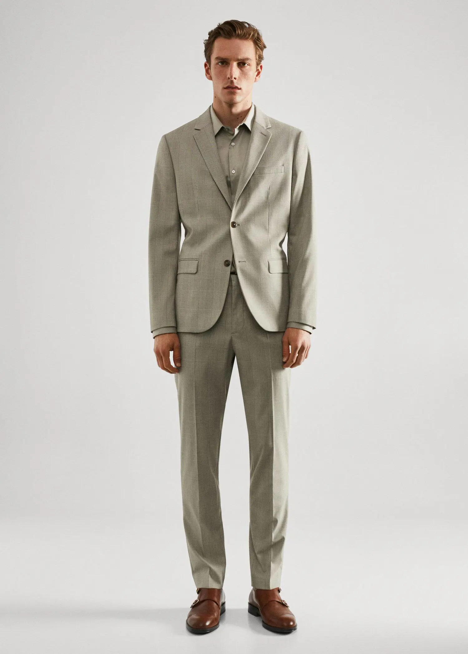 Mango Super slim-fit poplin suit shirt. a man in a suit standing in front of a white wall. 