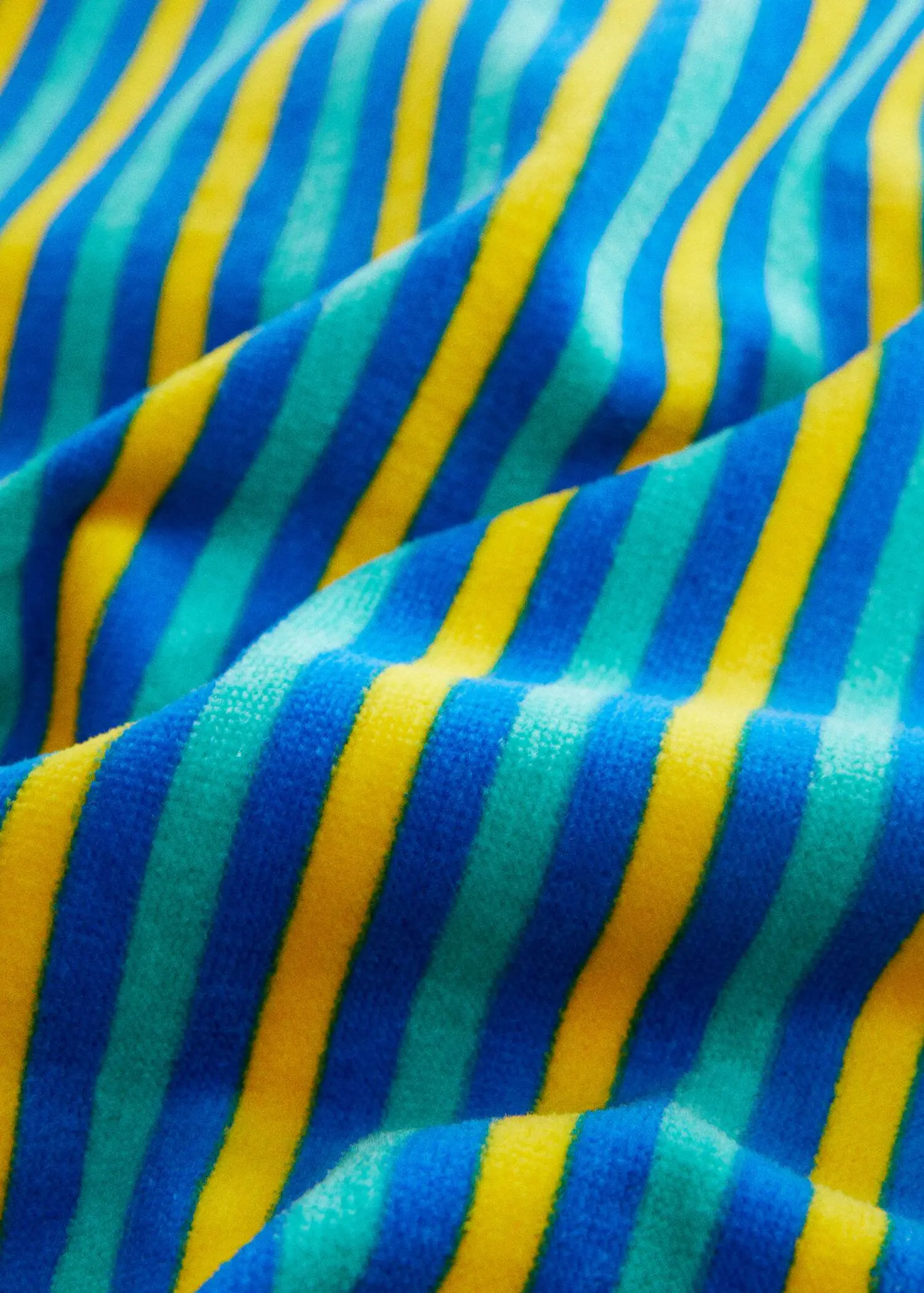 Mango Multi-coloured striped beach towel. a close-up view of a blue, yellow, and green striped fabric. 