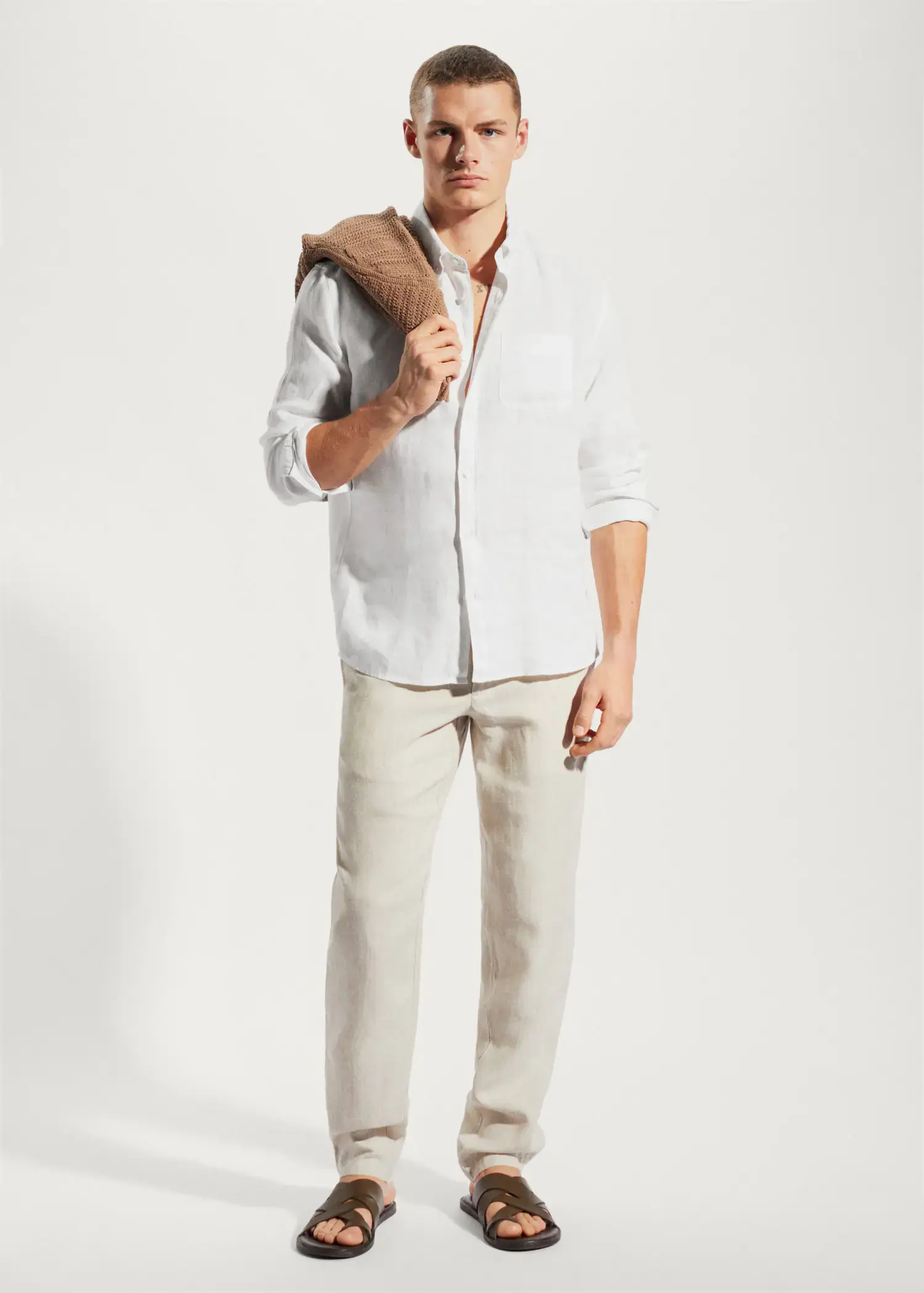 Mango 100% linen slim-fit shirt. a man in a white shirt and beige pants. 