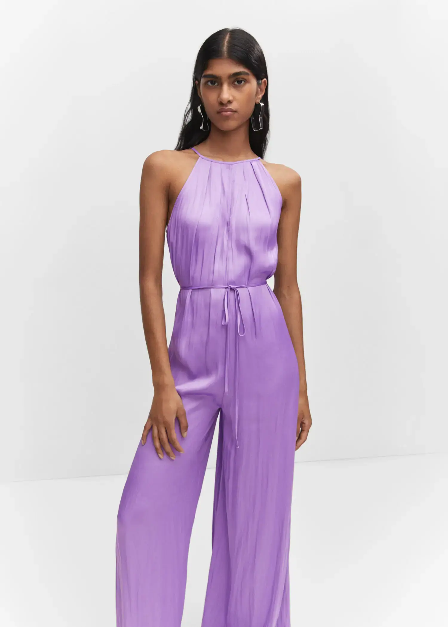 Mango Halter-neck satin jumpsuit. a woman wearing a purple jumpsuit standing in a room. 