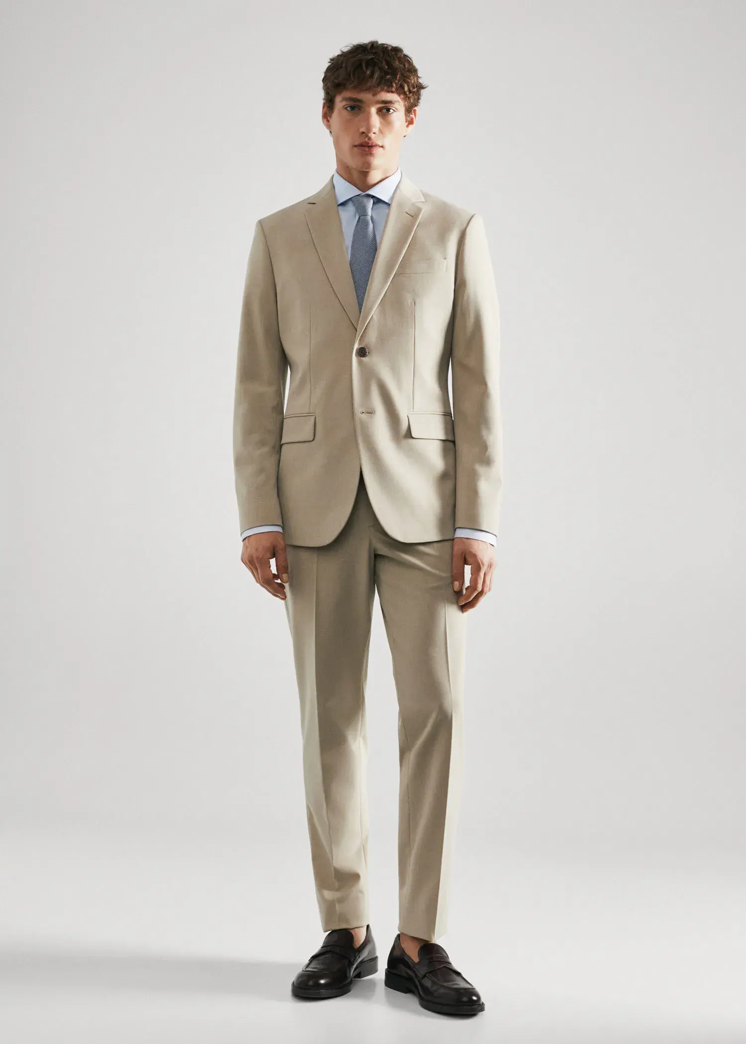 Mango Slim fit structured suit shirt. a man in a suit and tie standing in front of a white wall. 